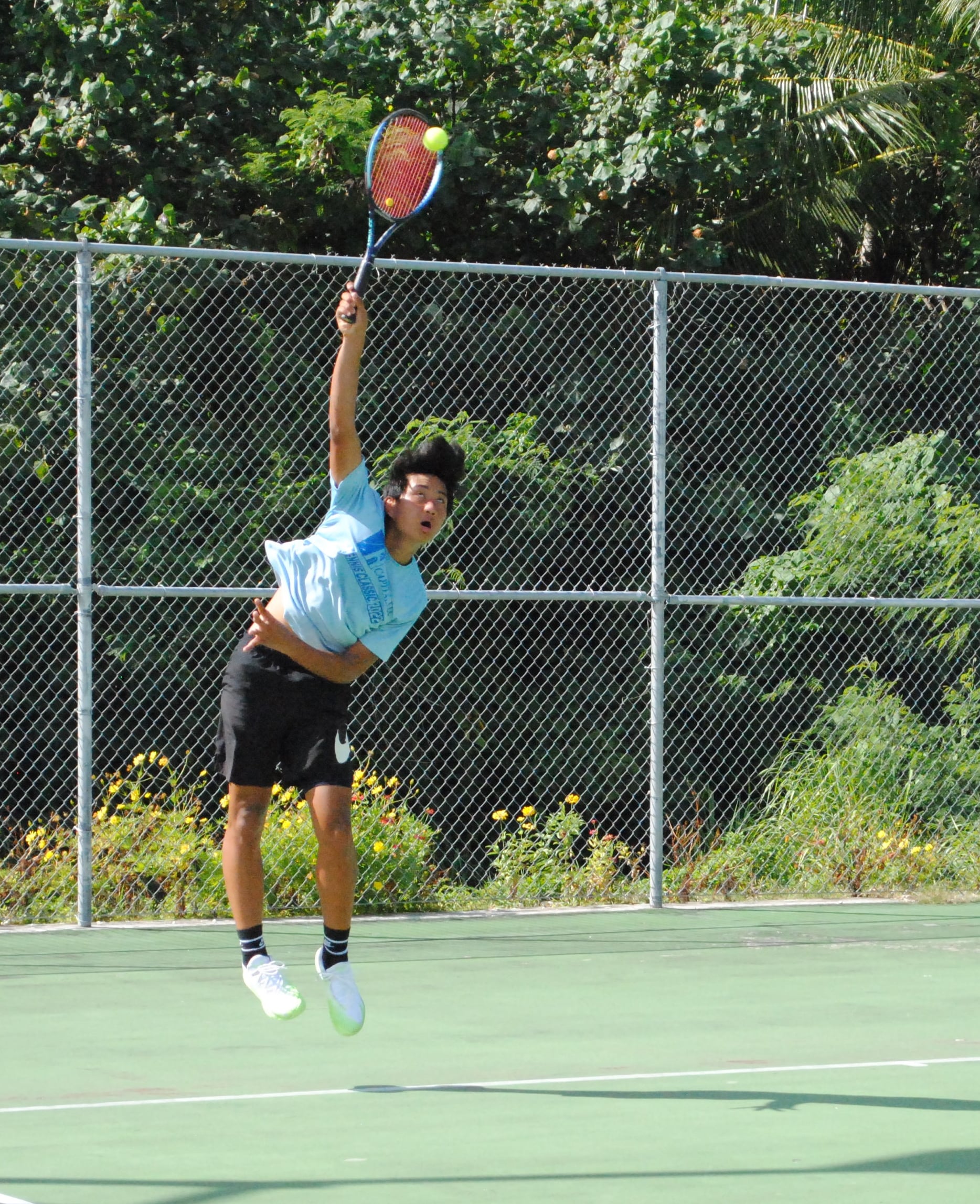 David Kwon connects the overhand serve during a TSL CNMI Junior Tennis Tournament game on Sunday at American Memorial Park.