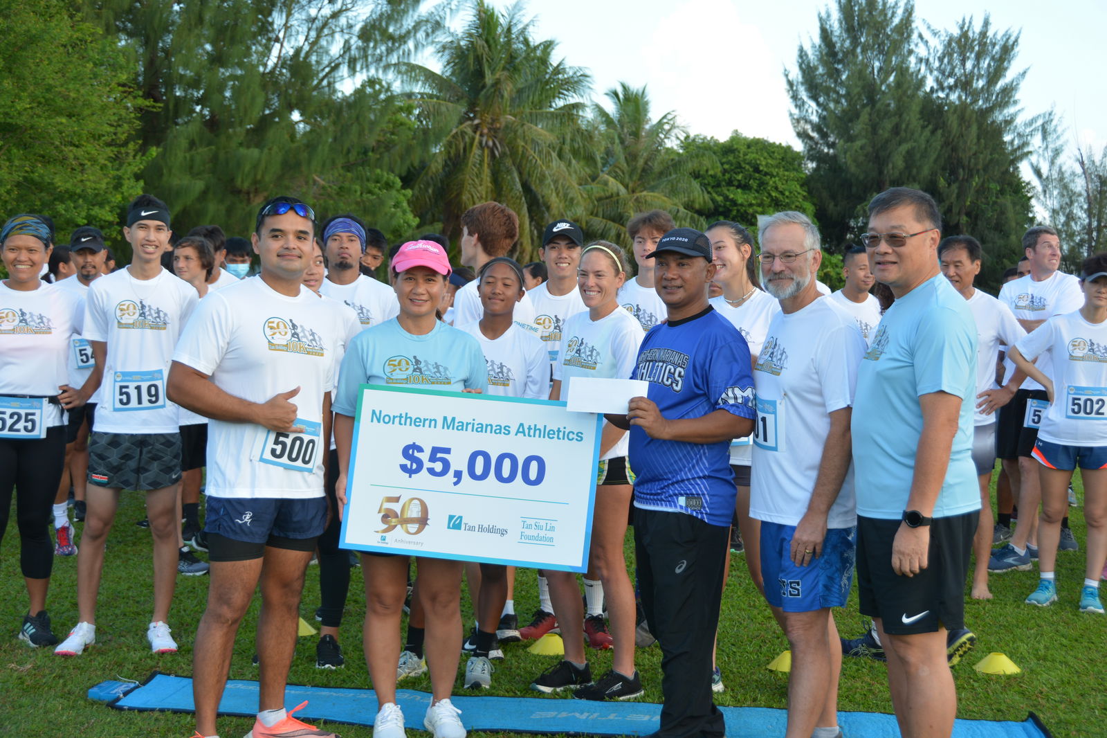 Northern Marianas Athletics general secretary Robin Sapong, fourth left, receives a $5,000 donation from the Tan Siu Lin Foundation during a turnover ceremony before the start of the Tan Holdings 50th Anniversary 10K Invitational Relay Run on Saturday at the Saipan golf course. Joining Sapong in the photo are NMI athlete Edward Dela Cruz, TSL Foundation executive director Merlie Tolentino, athlete Denise Myers, coach Ron Snyder, and Tan Holdings CEO Jerry Tan.