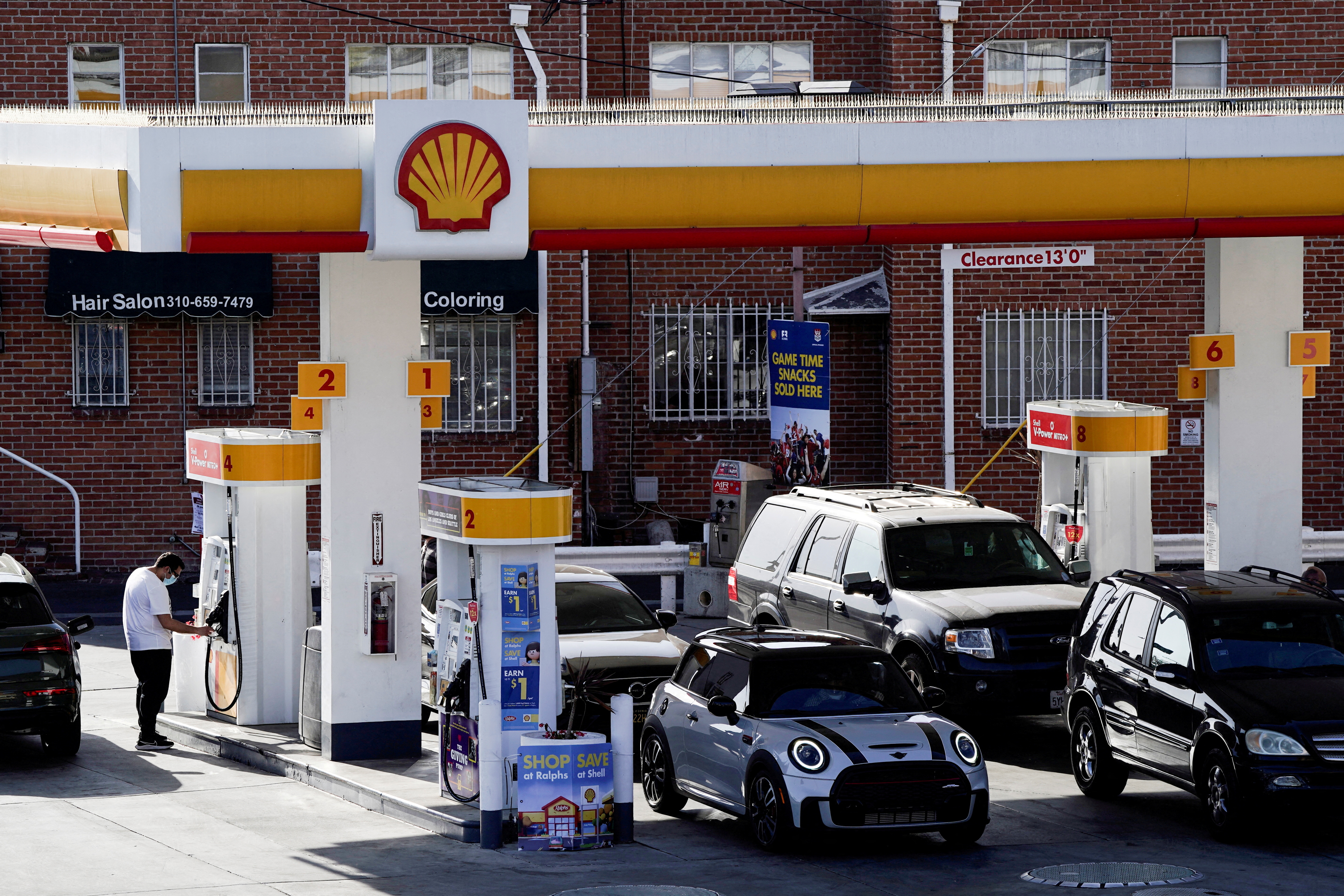 People refuel their vehicles with gasoline at a Shell gas station in Los Angeles, California, March 10, 2022.