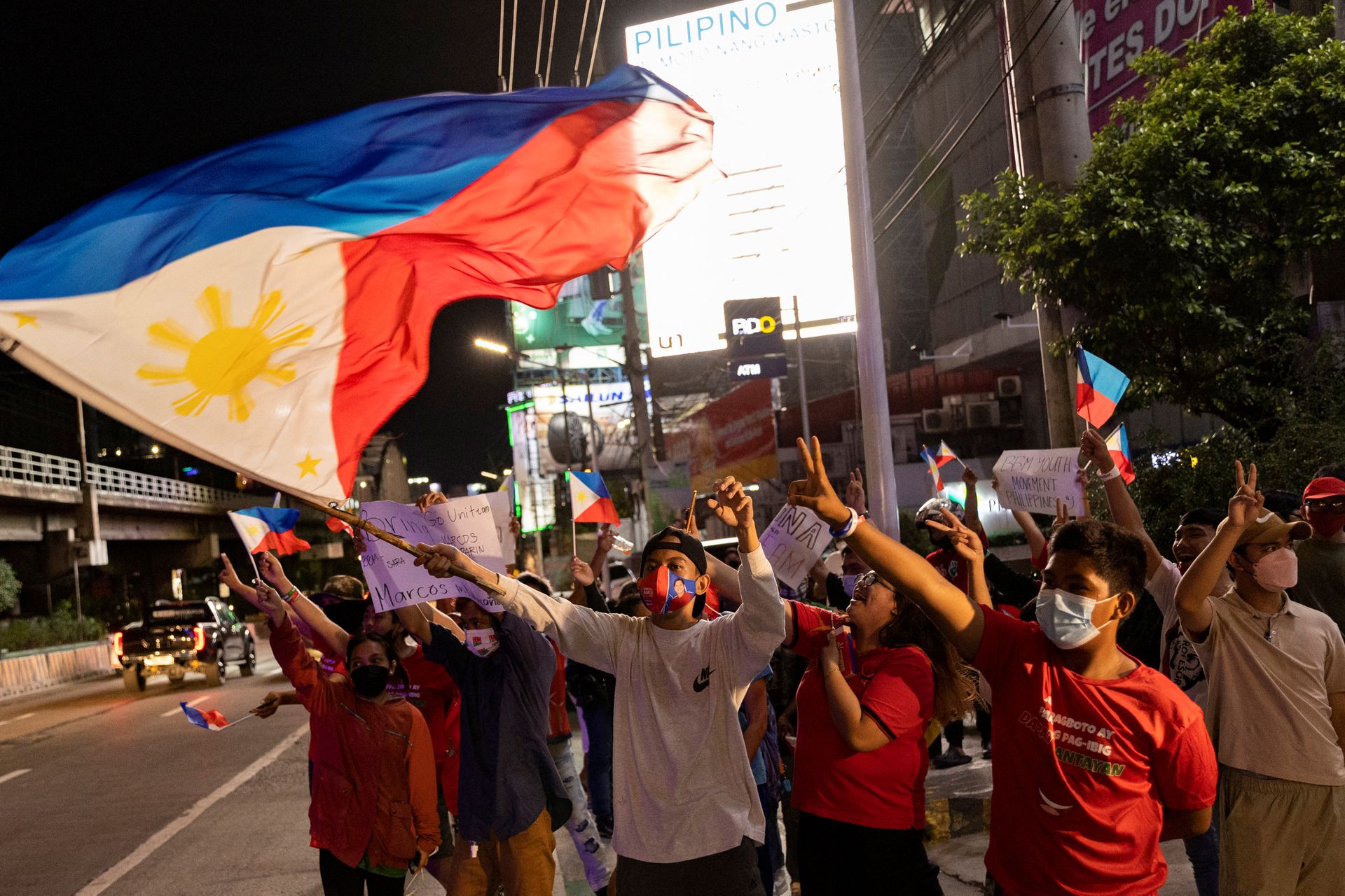 Supporters of presidential candidate Ferdinand "Bongbong" Marcos Jr. celebrate as partial results of the 2022 national elections show him with a wide lead over rivals, outside the candidate's headquarters in Mandaluyong City, Metro Manila, May 9, 2022.