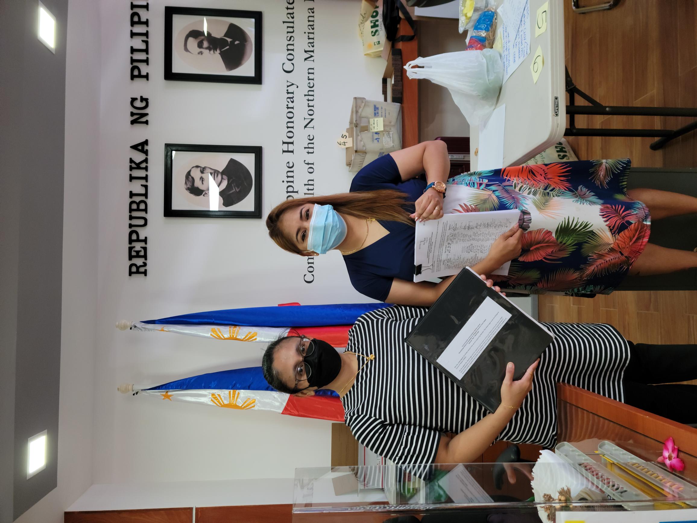 Maria Javier, right, presents a petition supporting the appointment of Marcelo “Mar” Masilungan as honorary Philippine consul to the CNMI to Philippine Vice Consul Sheila Mae Briones.