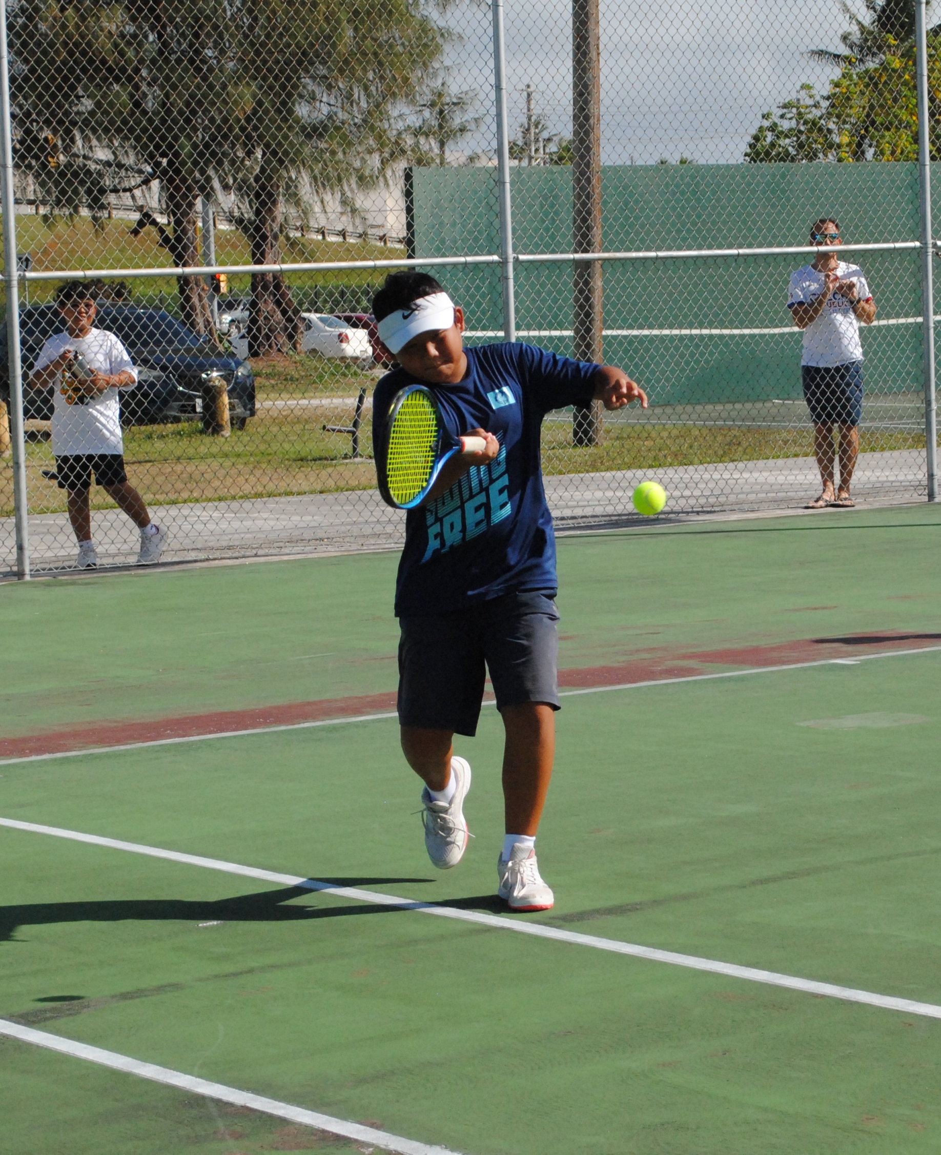 Ryan Choi attempts the front hand return during a boys doubles-12 game of the 2022 TSL CNMI Junior Tennis Tournament at  American Memorial Park.