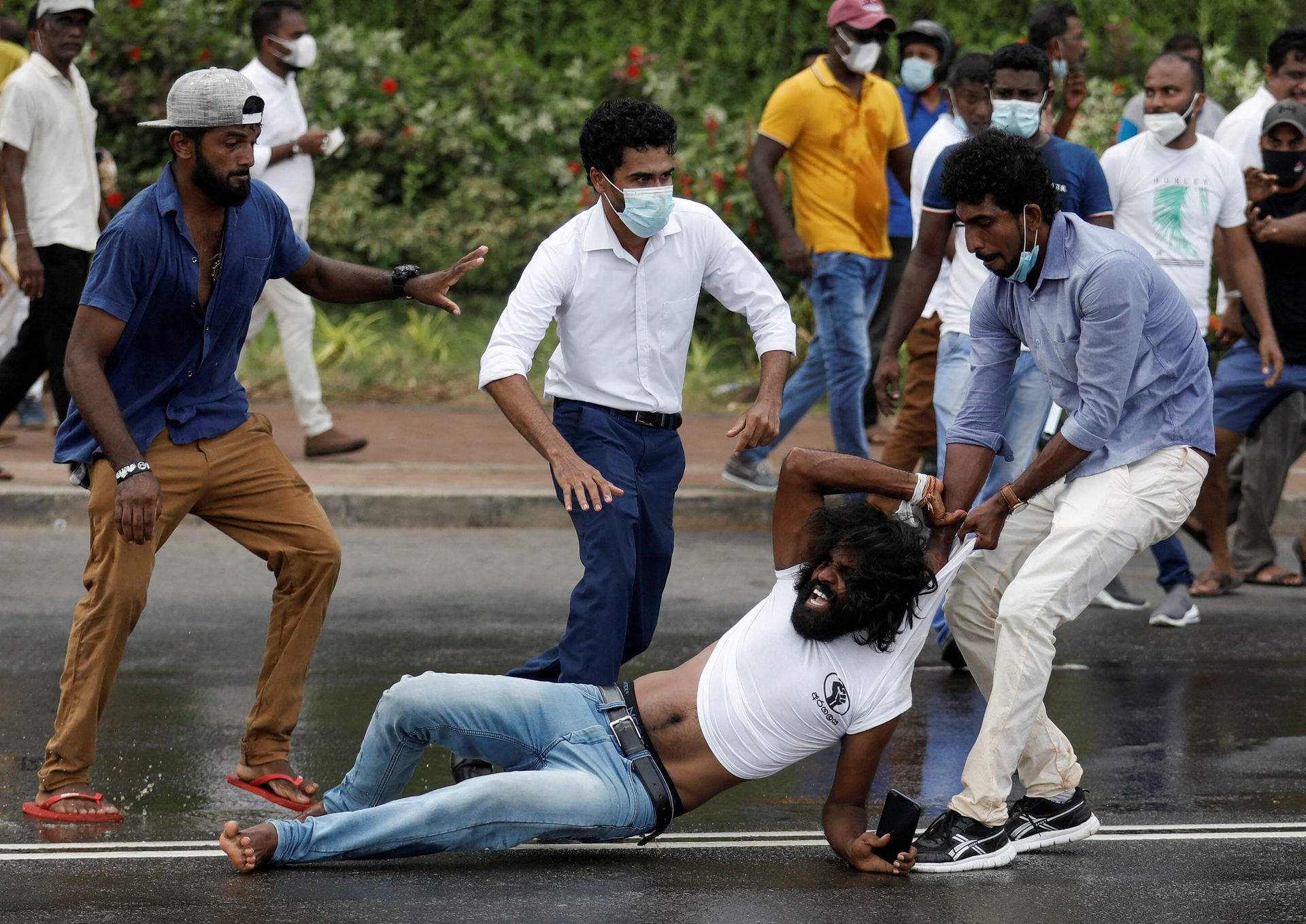 Supporter of Sri Lanka's ruling party tugs a member of anti-government demonstrator by his shirt during a clash between the two groups, amid the country's economic crisis in Colombo, Sri Lanka, May 9, 2022.