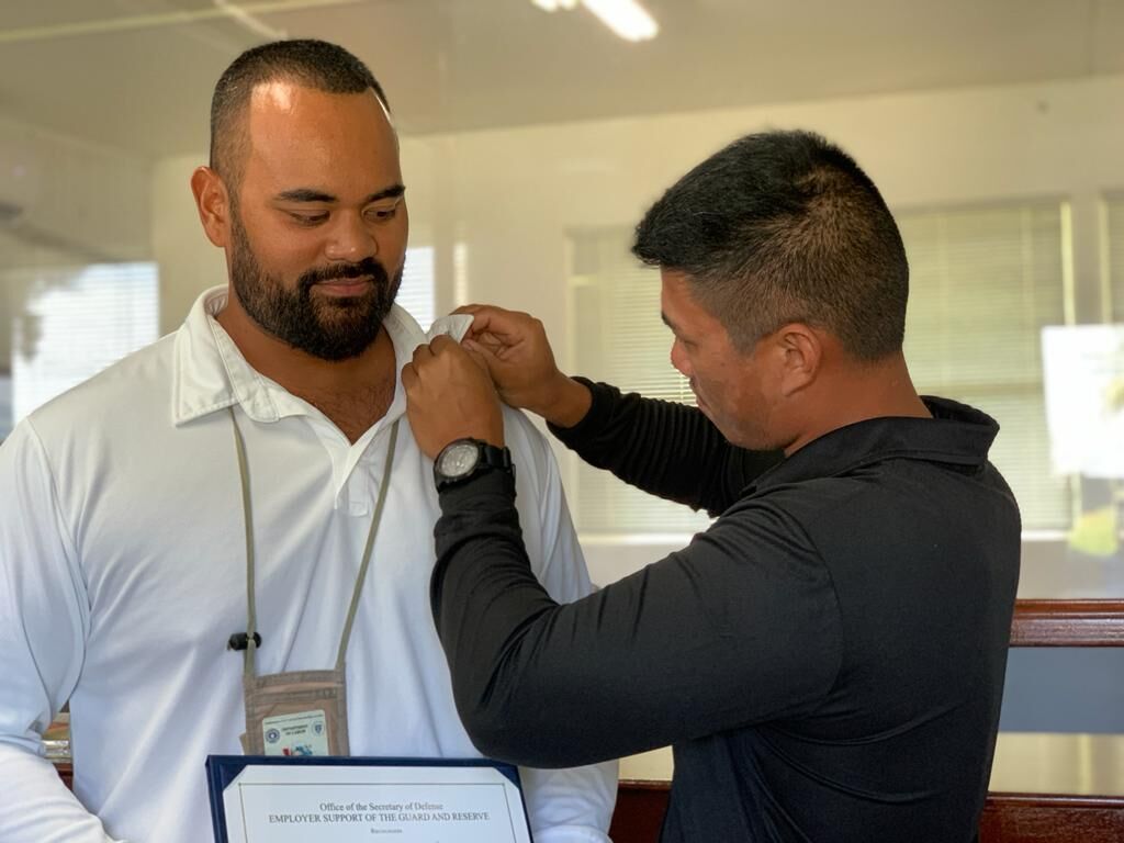 CNMI Department of Labor-Occupational Safety and Health Administration Program Manager Timothy Asaivao receives the Patriot Award and a pin  from servicemember Jerome Ignacio on May 5, 2022.