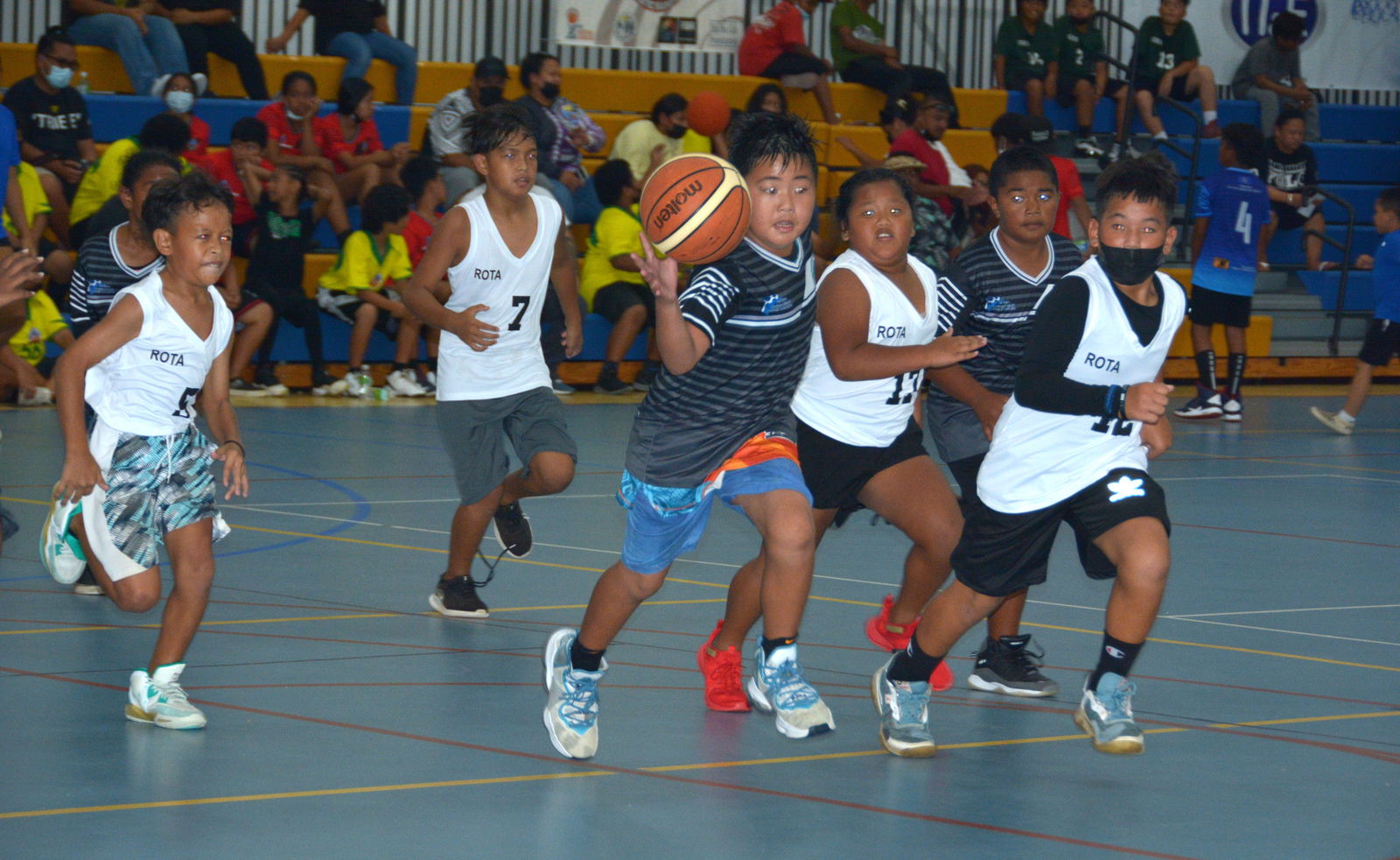 A Garapan Elementary School player, third left, dribbles while Rota’s Sinapalo Elementary School defenders chase him during a game of the 2021-2022 IT&E Interscholastic Co-ed Basketball League last month at the Marianas High School Gymnasium.