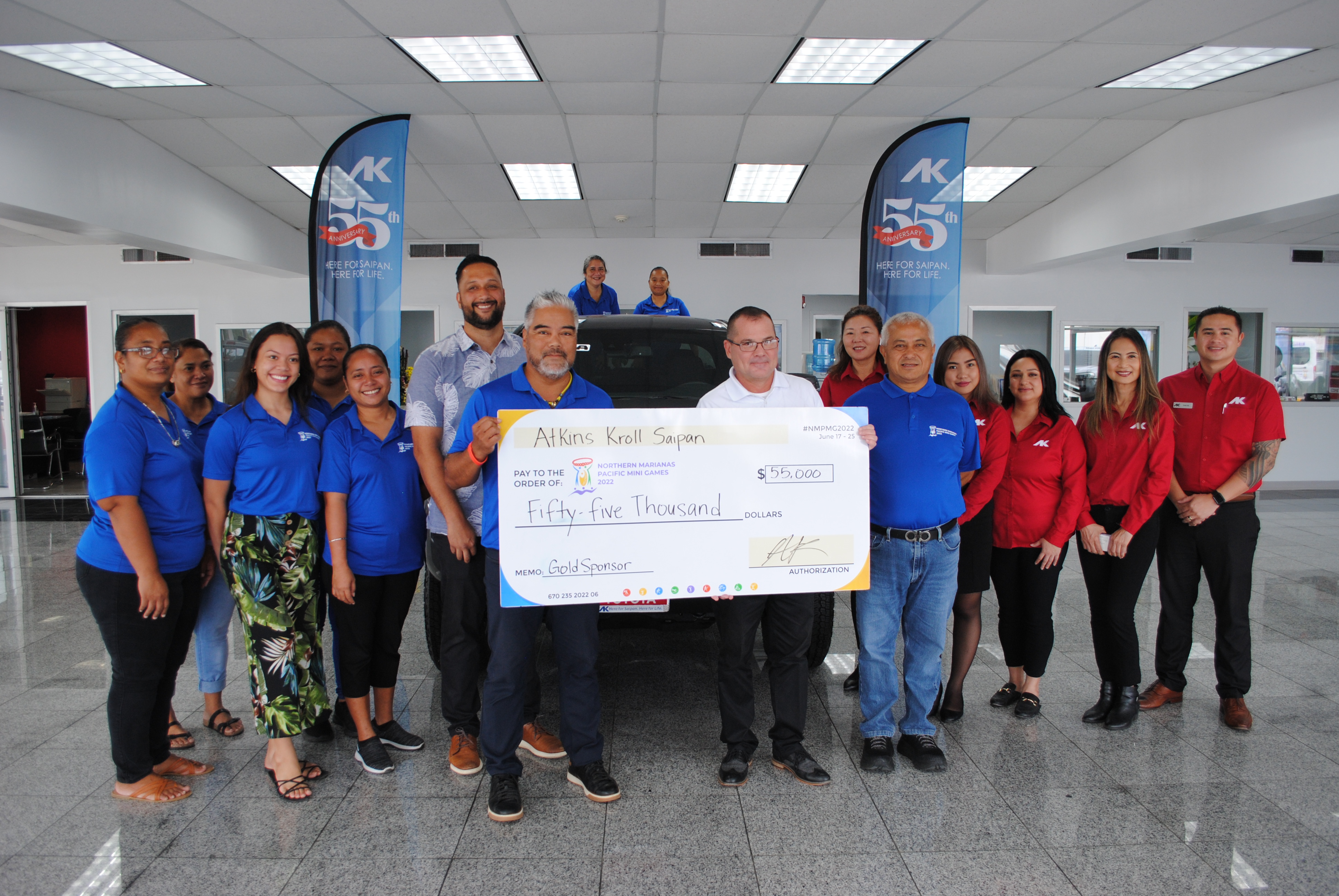 AK Saipan Sales Manager Kevin Barnes, with Pacific Mini Games Organizing Committee Chairman Marco Peter, AK Saipan General Manager Joel Lesh and organizing committee CEO Ben Babauta pose with  the AK Saipan sales  team and  organizing committee members during AK’s presentation of a check for $55,000 in its showroom on Thursday.