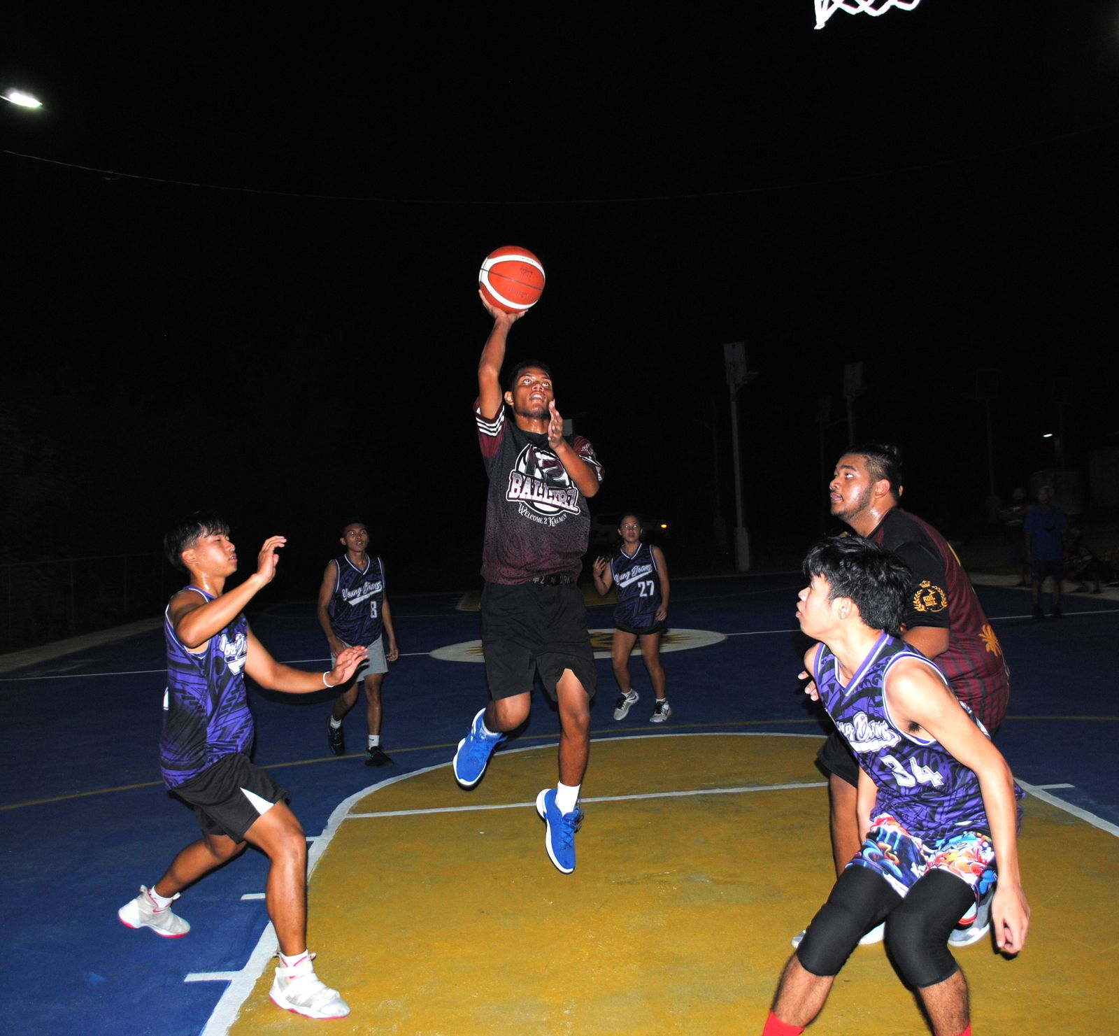 K2 Ballers' Gerald Manis takes the shot over two defenders during  the championship game of the P5 Hoops & Vibes Basketball Tournament at the Kagman Community Center basketball court on Saturday.