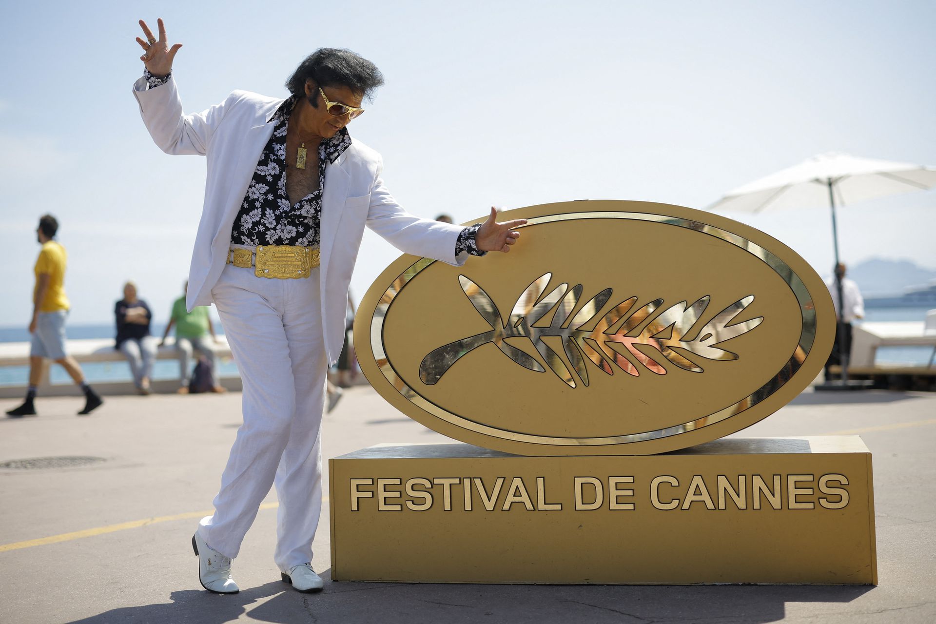 Elvis Presley impersonator Eryl Prayer poses on the Croisette near an installation of a Palme d'Or symbol ahead of the screening of the film "Elvis" at the 75th Cannes Film Festival in Cannes, France, May 25, 2022.