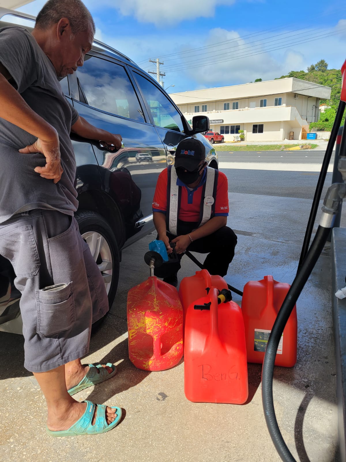 Tinian fisherman Boni Gonzales watches as a gas attendant fills his 5-gallon containers with gasoline at the Mobil Oil Marianas on Middle Road in Garapan Thursday.