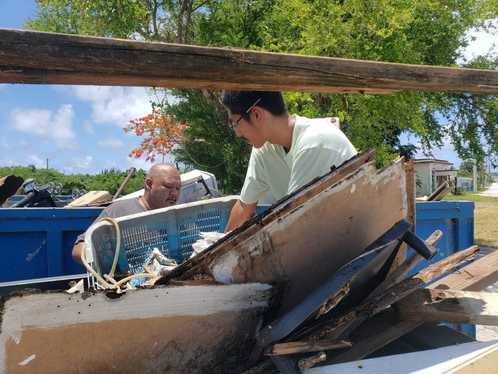 Rep. John Paul Sablan, left, assists a resident off-load his trash into the bins provided by the offices of Reps. Tina Sablan and John Paul Sablan during the Precinct 2 Spring Cleanup in Chalan Kanoa Saturday, May 21, 2022.