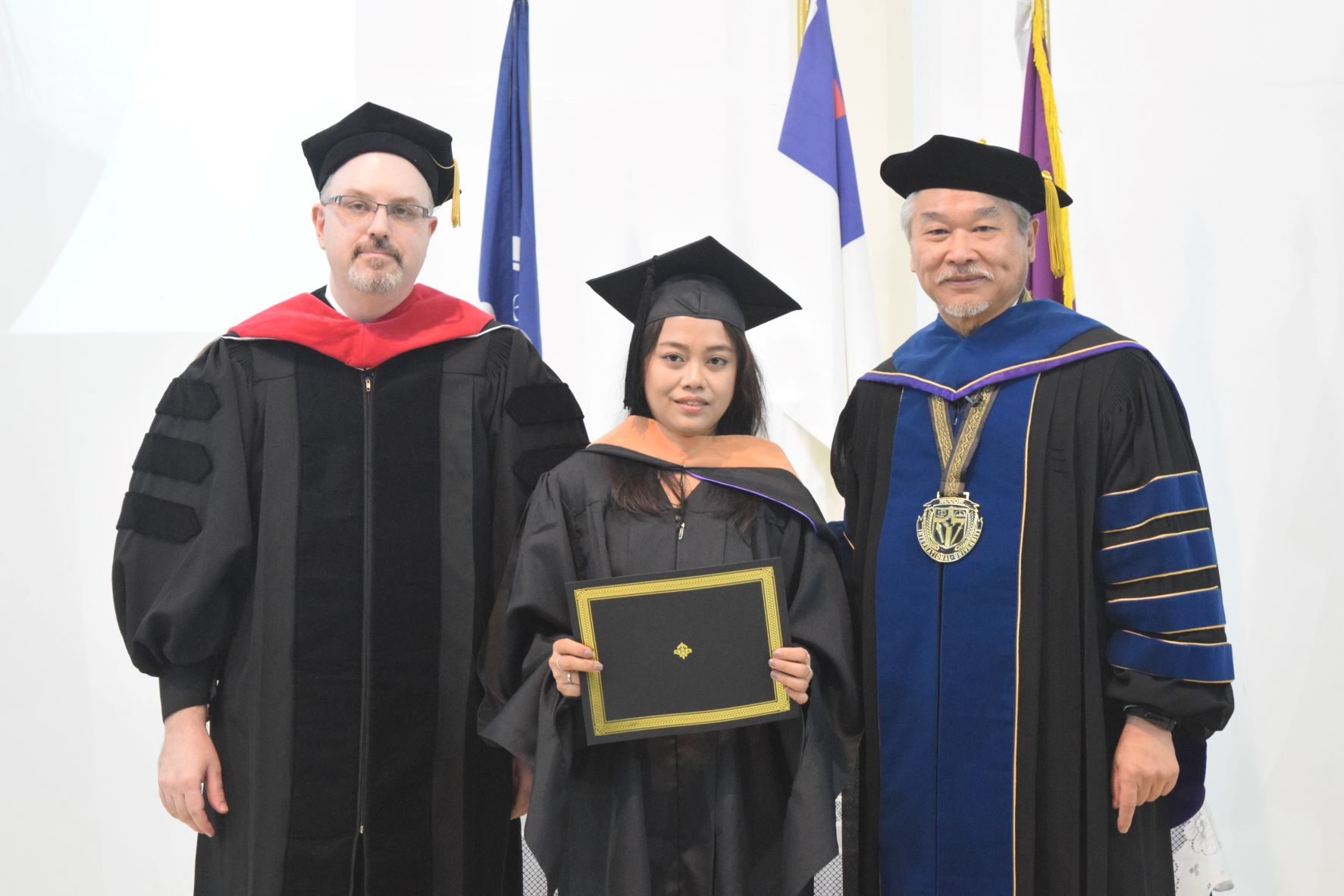 Masters of Business Administration graduate Hanna Hyesha Deleon poses for a photo with EUCON International University President/Administrator Dr. Christian Wei, right, and Vice President Dr. Sean Sartler.