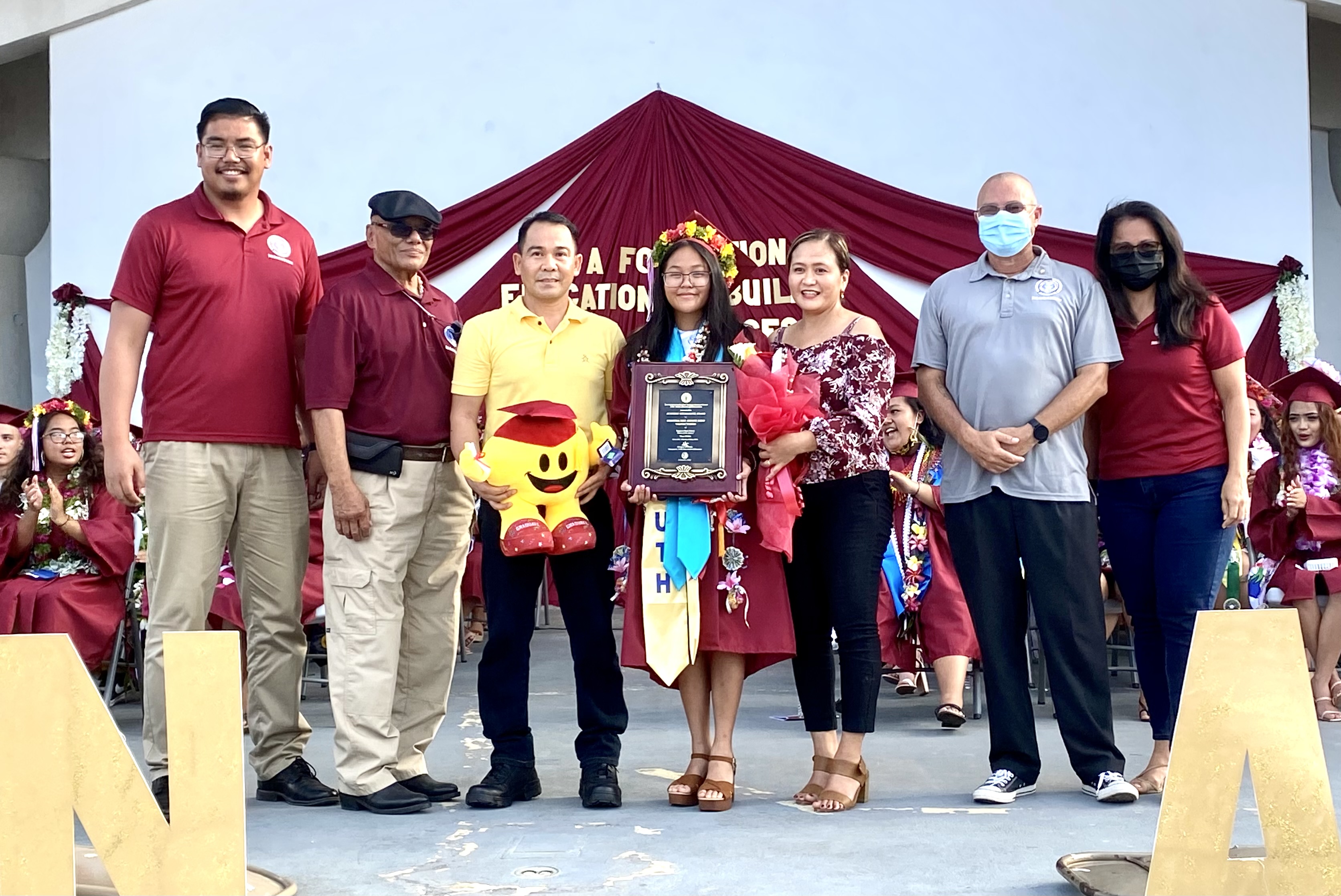 Shannea Mae Javate Dino, Class of 2022 valedictorian and recipient of the Board of Education Award, poses for  a photo with her parents, BOE Chairman Gregory Pat Borja, Vice Chairman Antonio L. Borja, Secretary Treasurer Maisie B. Tenorio, and Board Member Herman Atalig.