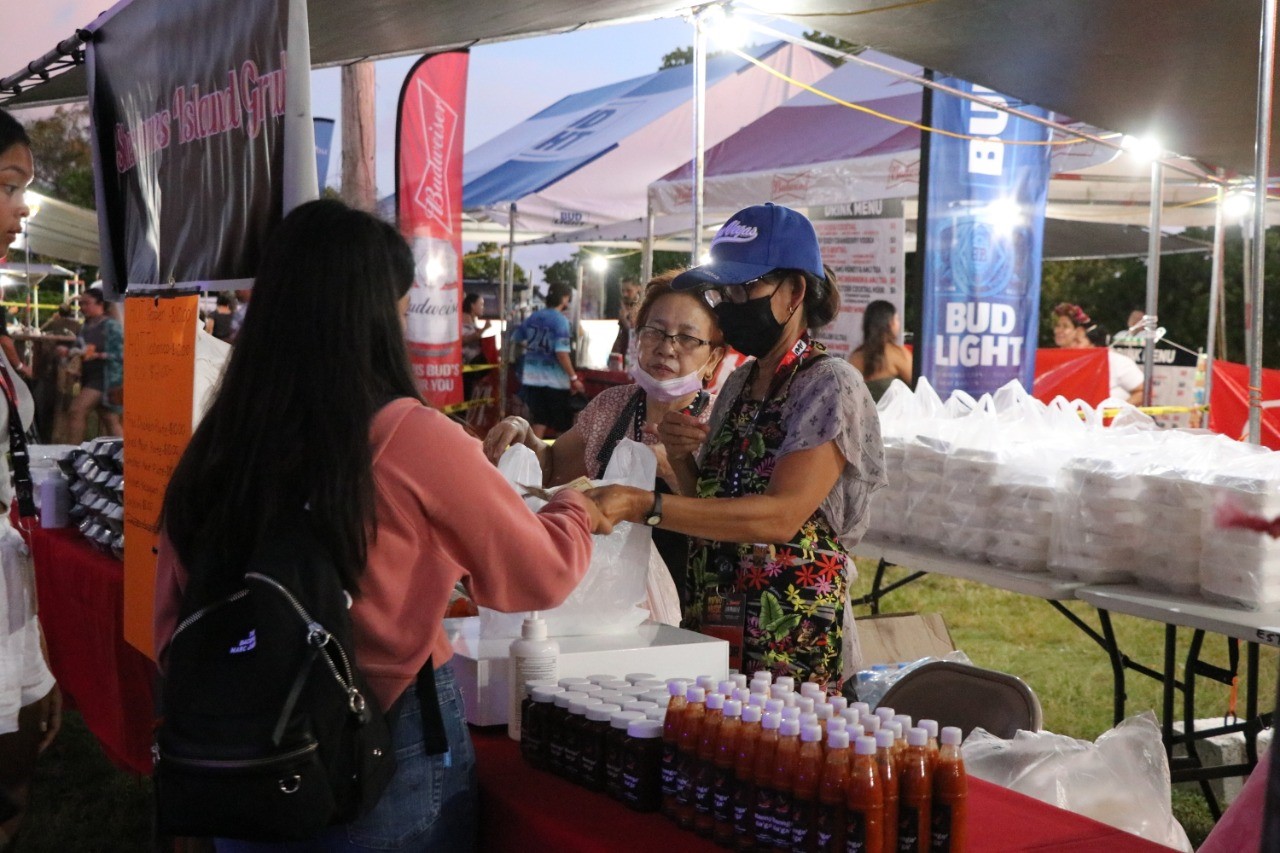 A festivalgoer receives food from one of the vendors on Friday.