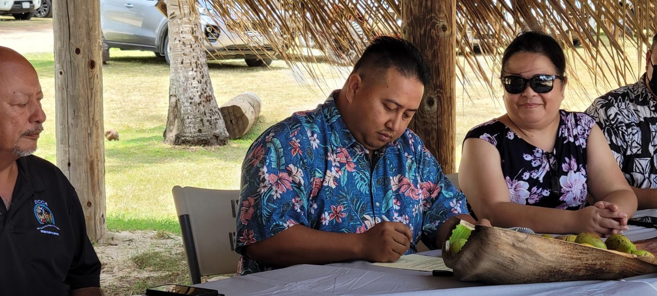 Gov. Ralph DLG Torres signs the proclamation as DCCA Secretary Joseph Guerrero and HPO Director Rita Chong look on.