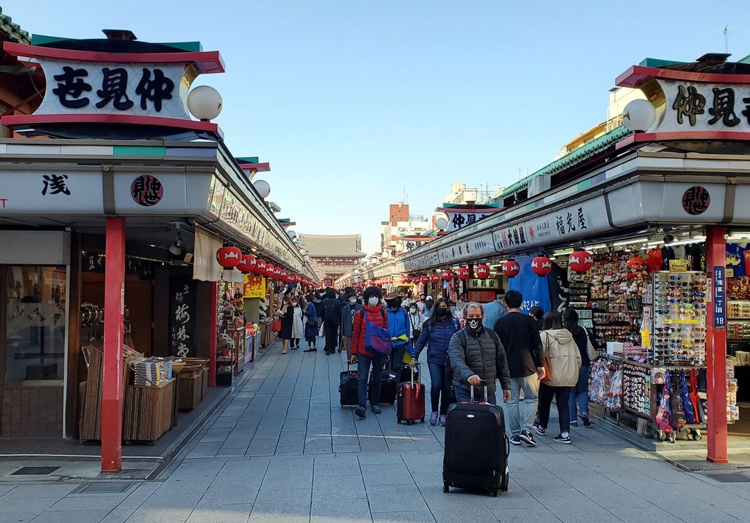 Tourists wearing protective face masks following an outbreak of the coronavirus disease are seen at the Asakusa district in Tokyo, Japan, March 25, 2020.