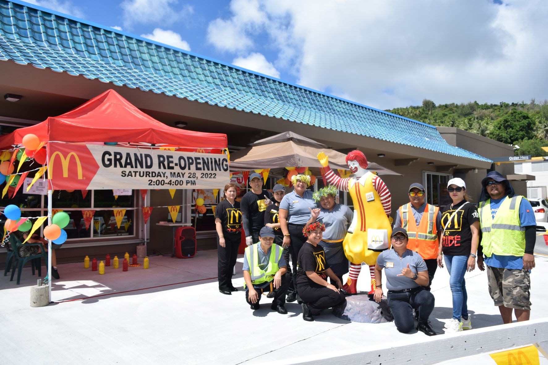 McDonald's Restaurant Saipan Middle Road general manager Joyce Asistores, left, service crew and maintenance staff pose next to the games and activity booths during their grand reopening on Saturday.