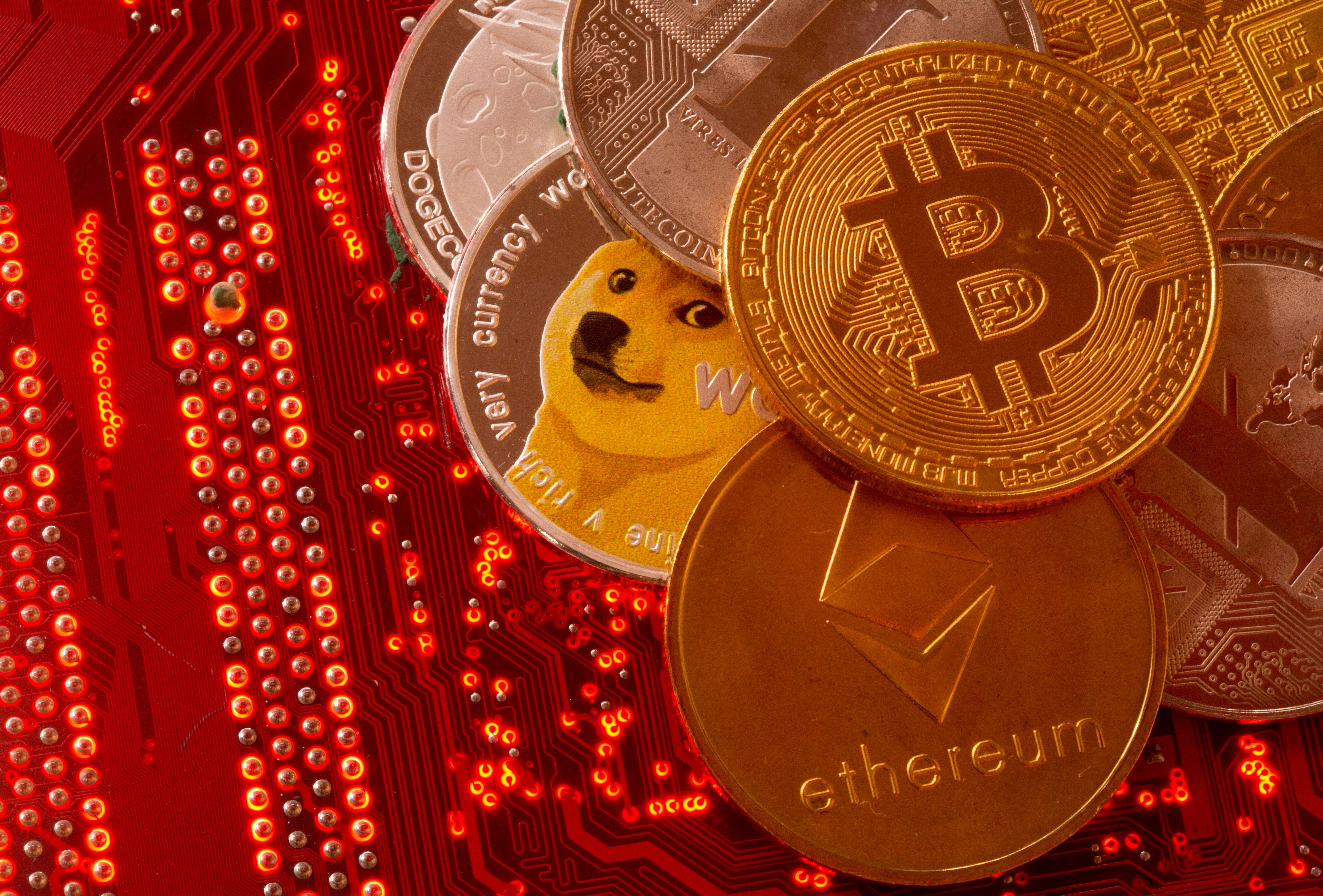 Representations of cryptocurrencies Bitcoin, Ethereum, DogeCoin, Ripple, Litecoin are placed on PC motherboard in this illustration taken on June 29, 2021.