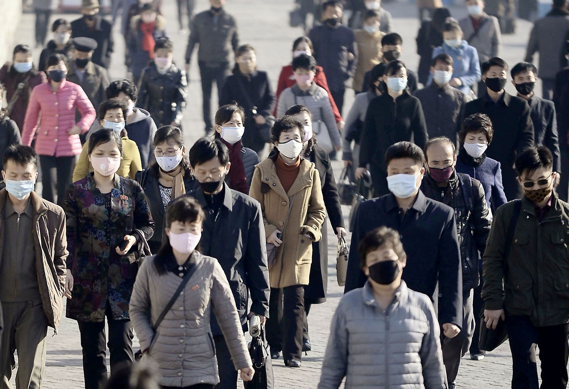 People wearing protective face masks commute amid concerns over the new coronavirus disease in Pyongyang, North Korea on March 30, 2020.