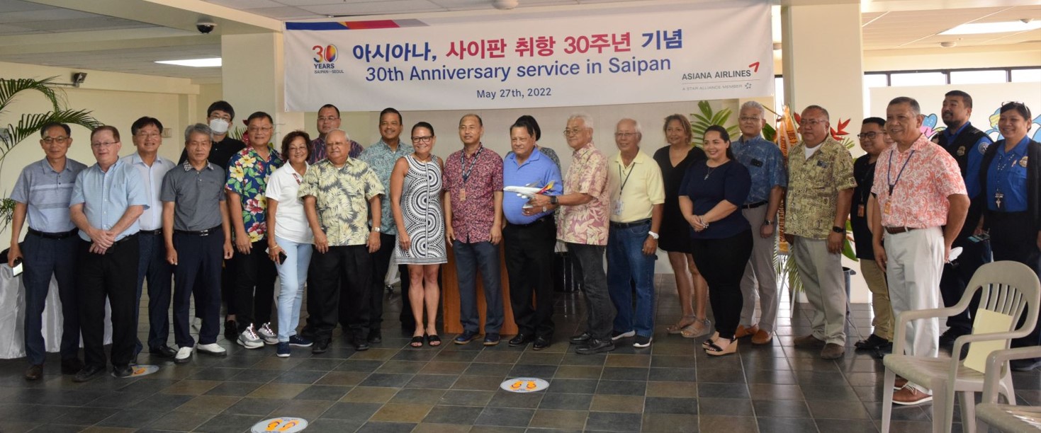 Asiana Airlines Regional Sales Office General Manager Intak Hwang, center, poses for a photo with CNMI, Commonwealth Ports Authority and Marianas Visitors Authority officials during a celebration of the airlines' 30th anniversary of its Saipan flight service at the Francisco C. Ad/Saipan International Airport on Saturday.