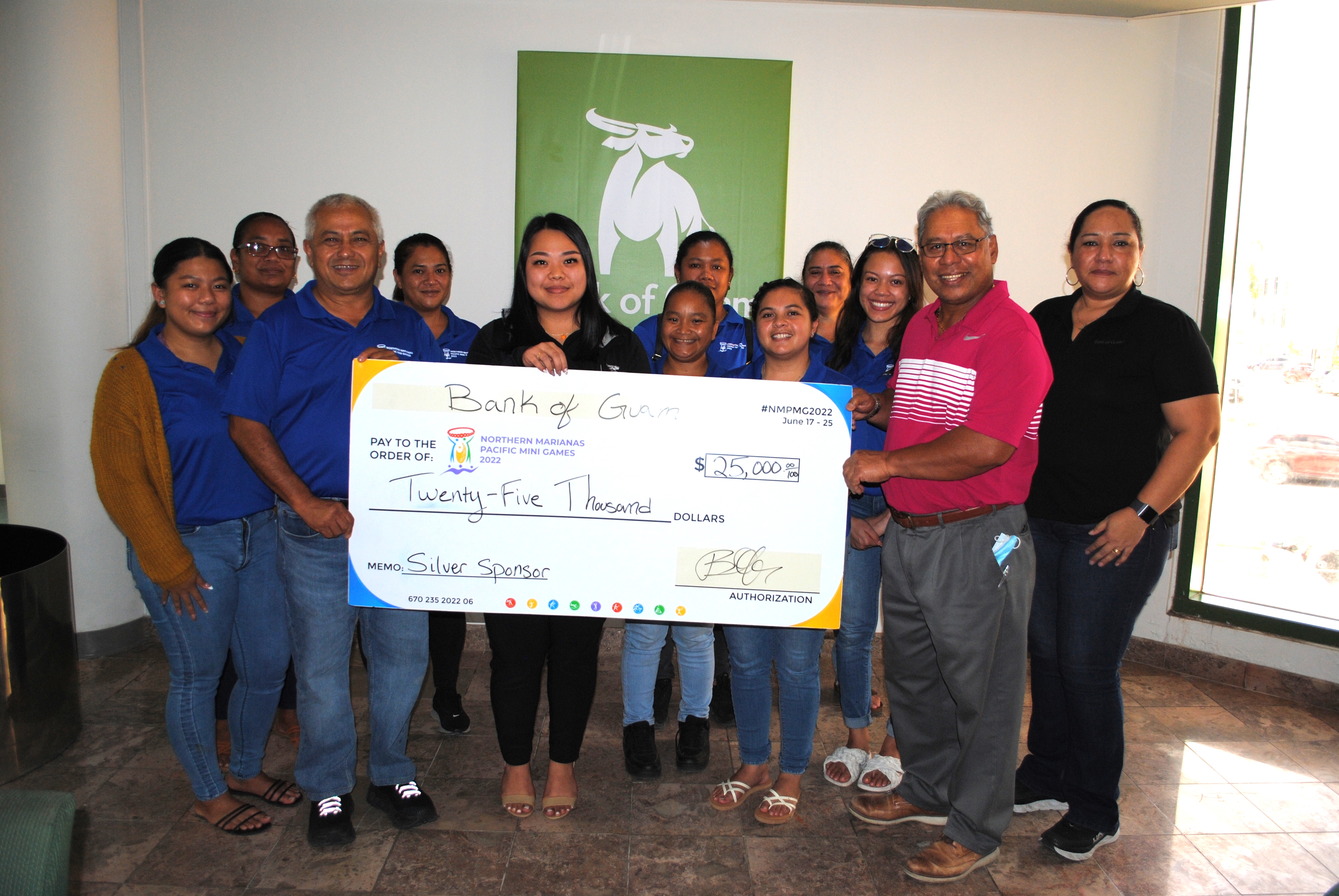 2022 Pacific Mini Games Organizing Committee  CEO Ben Babauta, third left, poses with Bank of Guam Garapan branch manager Larry Phillip, assistant vice president/operations manager Tania David along with the games organizing committee members at  BoG Garapan where the committee received a check for $25,000 from the bank.