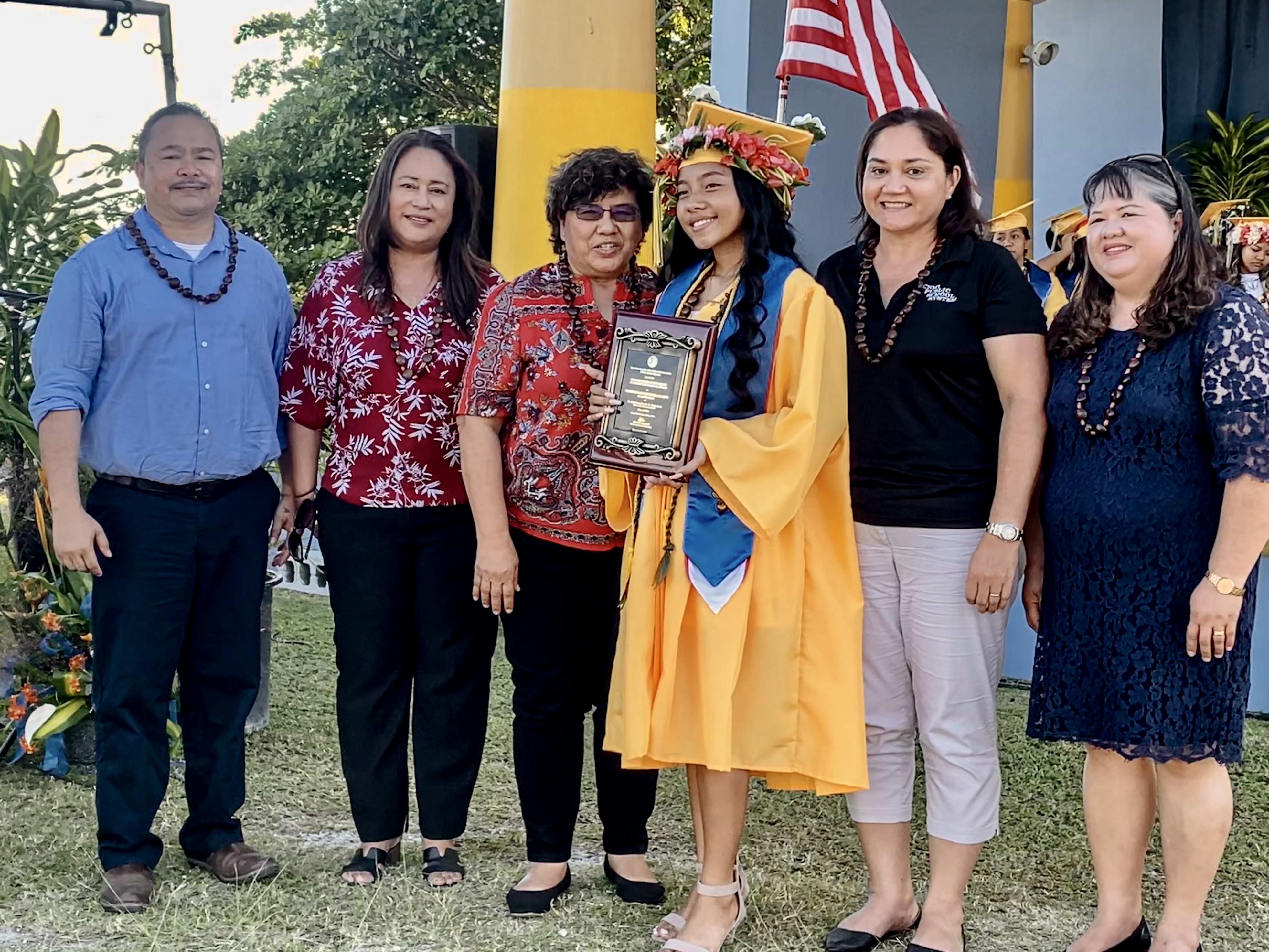 Doctor Rita Hocog Inos High School salutatorian Namiko Nani Mendiola Calvo receives the Commissioner of Education Award from Education Commissioner Dr. Alfred B. Ada, left. Also in photo are Public School System Senior Directors Dr. Yvonne Pangelinan, Jackie Quitugua, Dr. Rizalina Liwag and Special Education Director Donna Flores.