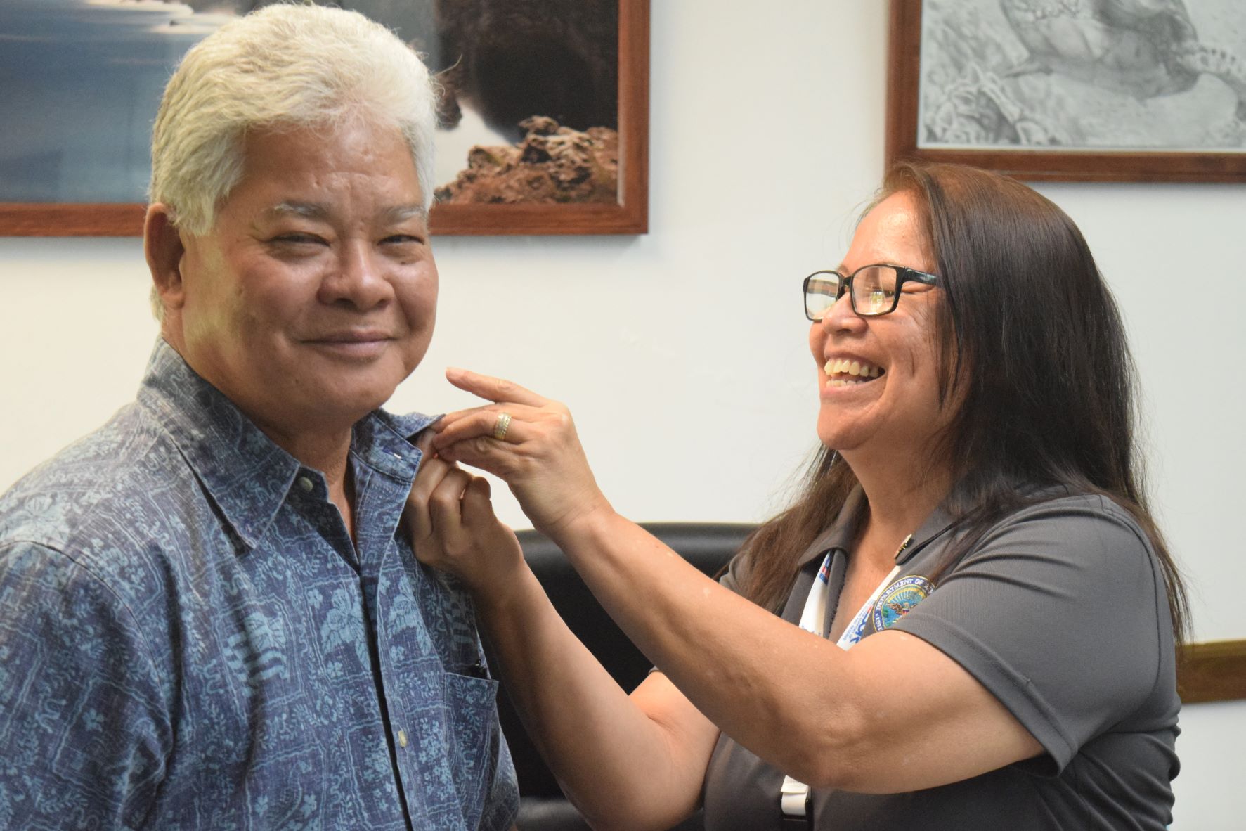 ESGR Guam-CNMI area chair Rita A. Sablan, Ed. D puts a “grand supporter” pin on Lt. Gov. Arnold I. Palacios' collar.