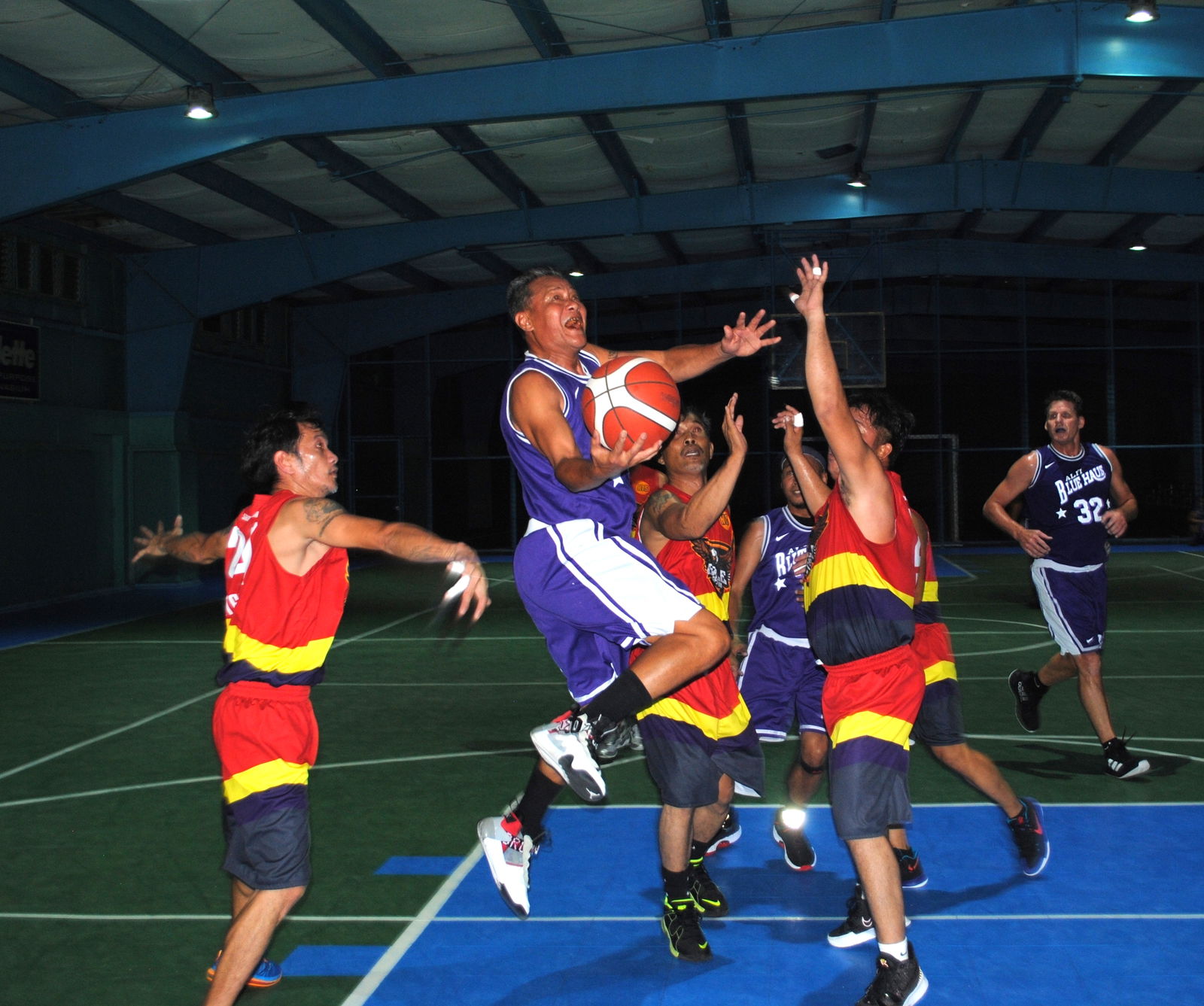 BlueHaus' Ed Diaz slips past three defenders for the finish during game 1 of the championships series against Eagles Construction in the masters division of the Saipan Centennial Lions Club Basketball League at TSL Sports Complex on Friday.
