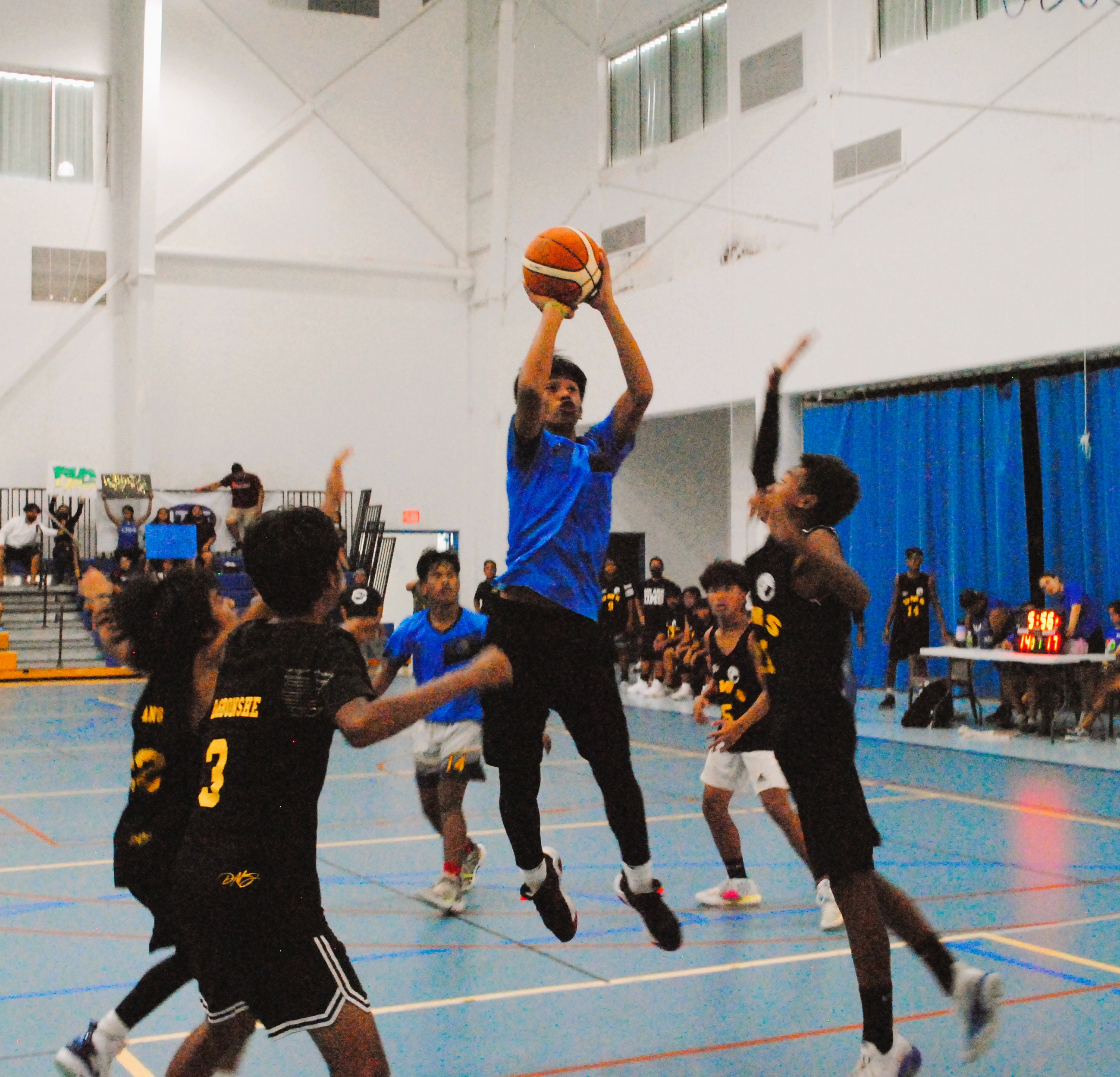 FMS's Christian Lucero pulls up for the fadeaway shot over three defenders during a game of the IT&E Interscholastic Boys Middle School Basketball League at the MHS gym.