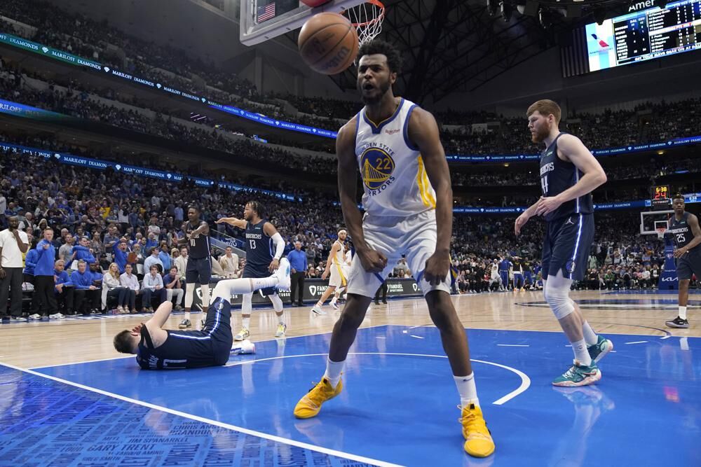 Golden State Warriors forward Andrew Wiggins (22) celebrates after dunking the ball over Dallas Mavericks guard Luka Doncic, left, during the second half of Game 3 of the NBA basketball playoffs Western Conference finals, Sunday, May 22, 2022, in Dallas.