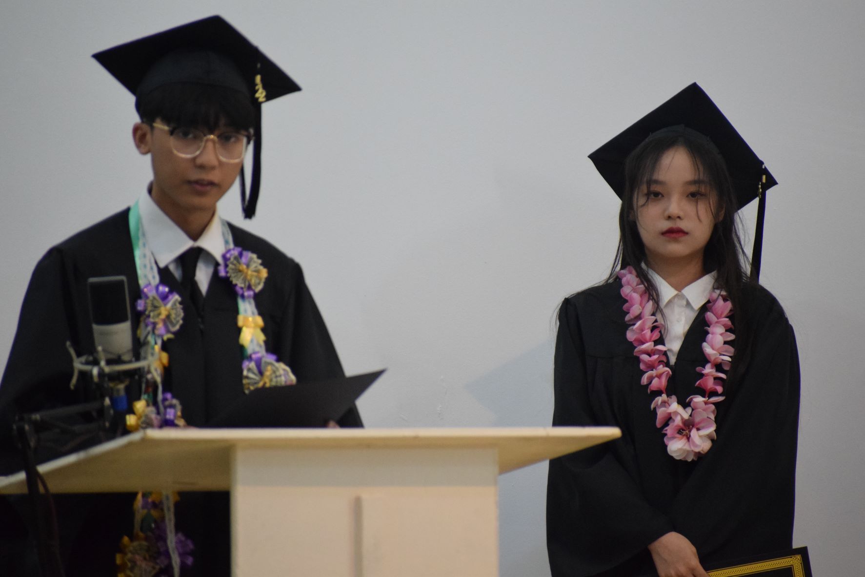Janvien Carlo Pascua delivers his speech while the Dean's Award recipient, Wang Ze Ying, waits for her turn.