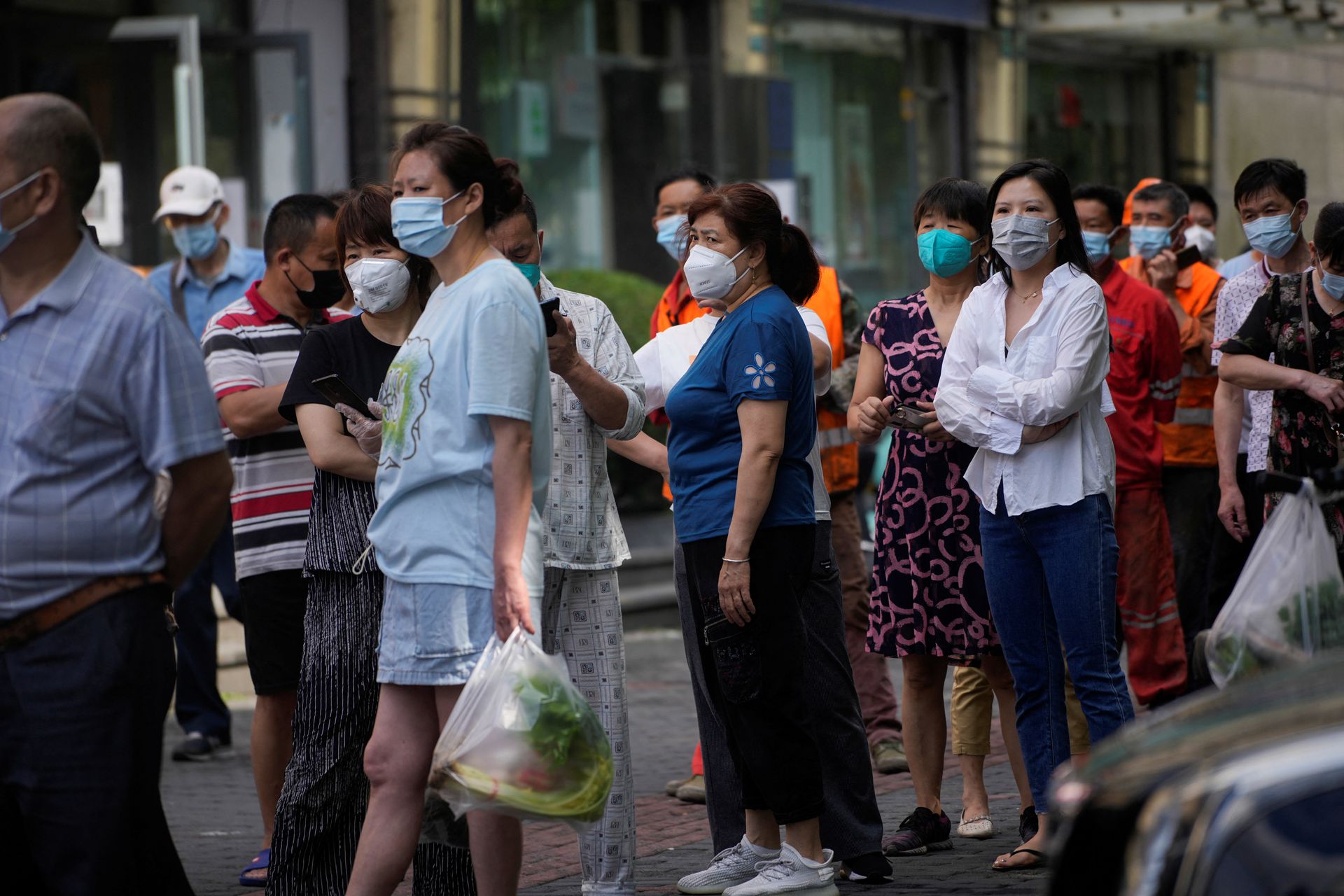 People line up for nucleic acid tests on a street, amid new lockdown measures in parts of the city to curb the coronavirus disease outbreak in Shanghai, China, June 11, 2022.