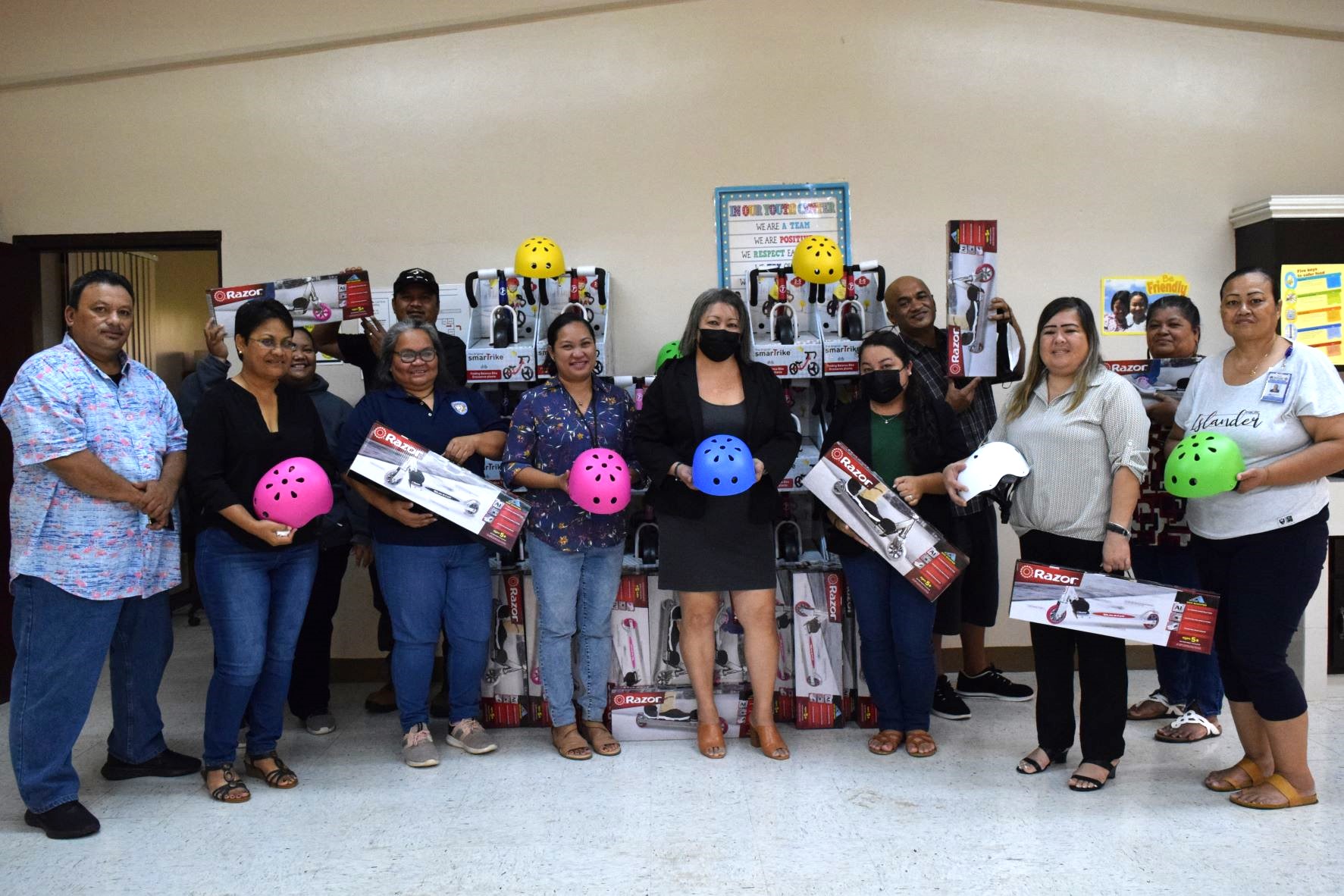 Sen. Edith Deleon Guerrero, center, poses for a photo with Division of Youth Services Administrator Vivian Sablan, third right, and DYS staff during the turnover of trikes and scooters for children at the Tanapag Youth Center on Thursday.
