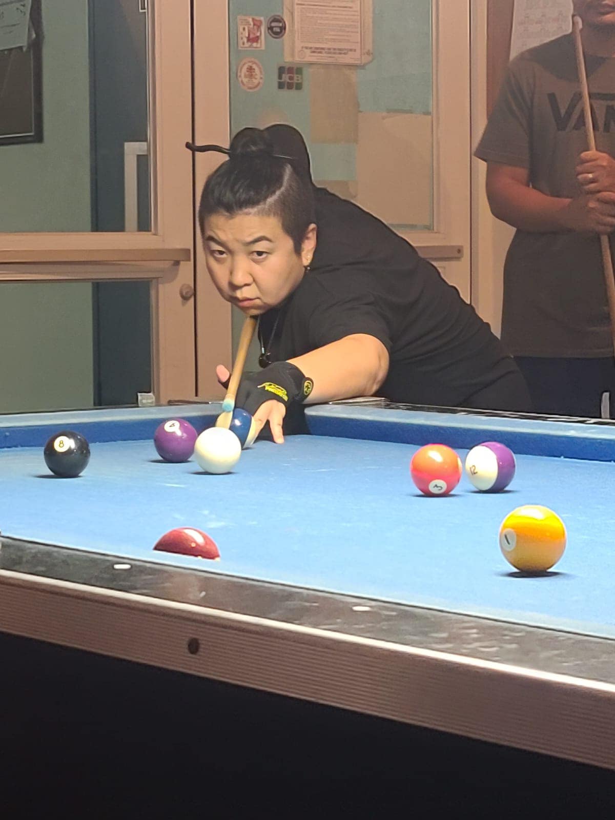 VFW No Regret's Mei Rengiil lines up for the slice shot during a Thursday Division game of the SBA Budweiser Open 8-Ball League.