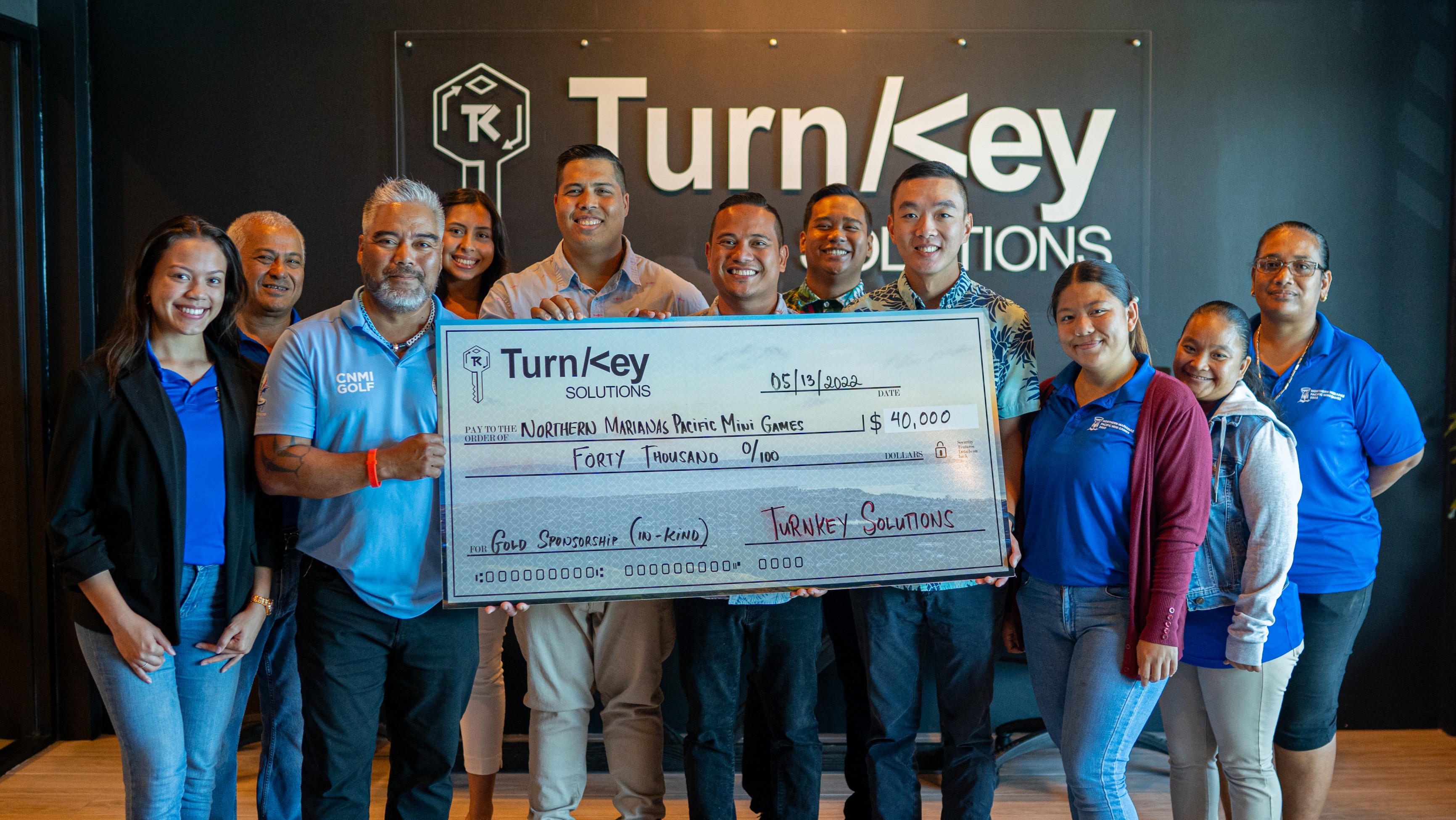 TurnKey Solutions' Managing Partners Billy Grow, Broc Calvo and Jerry Lin, center, along with Marketing & Branding Manager Liana Cotero, fourth left, and Client Services Supervisor Adrian Tangcoy, fifth right, pose for a photo with 2022 Pacific Mini Games Organizing Committee Chairman Marco Peter, CEO Ben Babauta and committee members. TurnKey donated a check for $40,000 to the Mini Games which the CNMI will host on June 17-25.