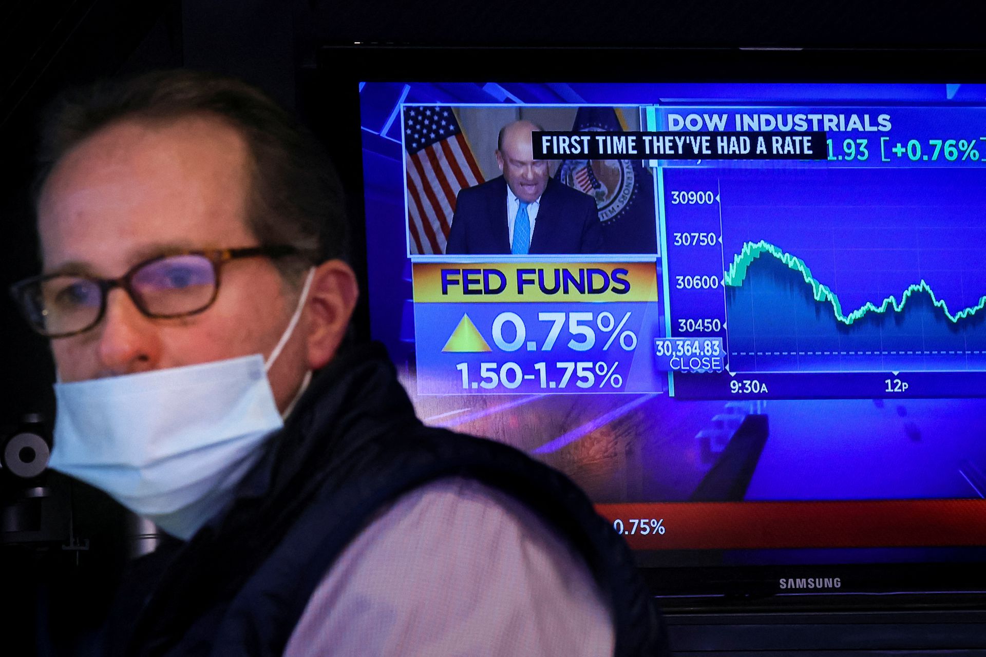 A screen displays the Fed rate announcement as a trader works on the floor of the New York Stock Exchange in New York City, June 15, 2022.