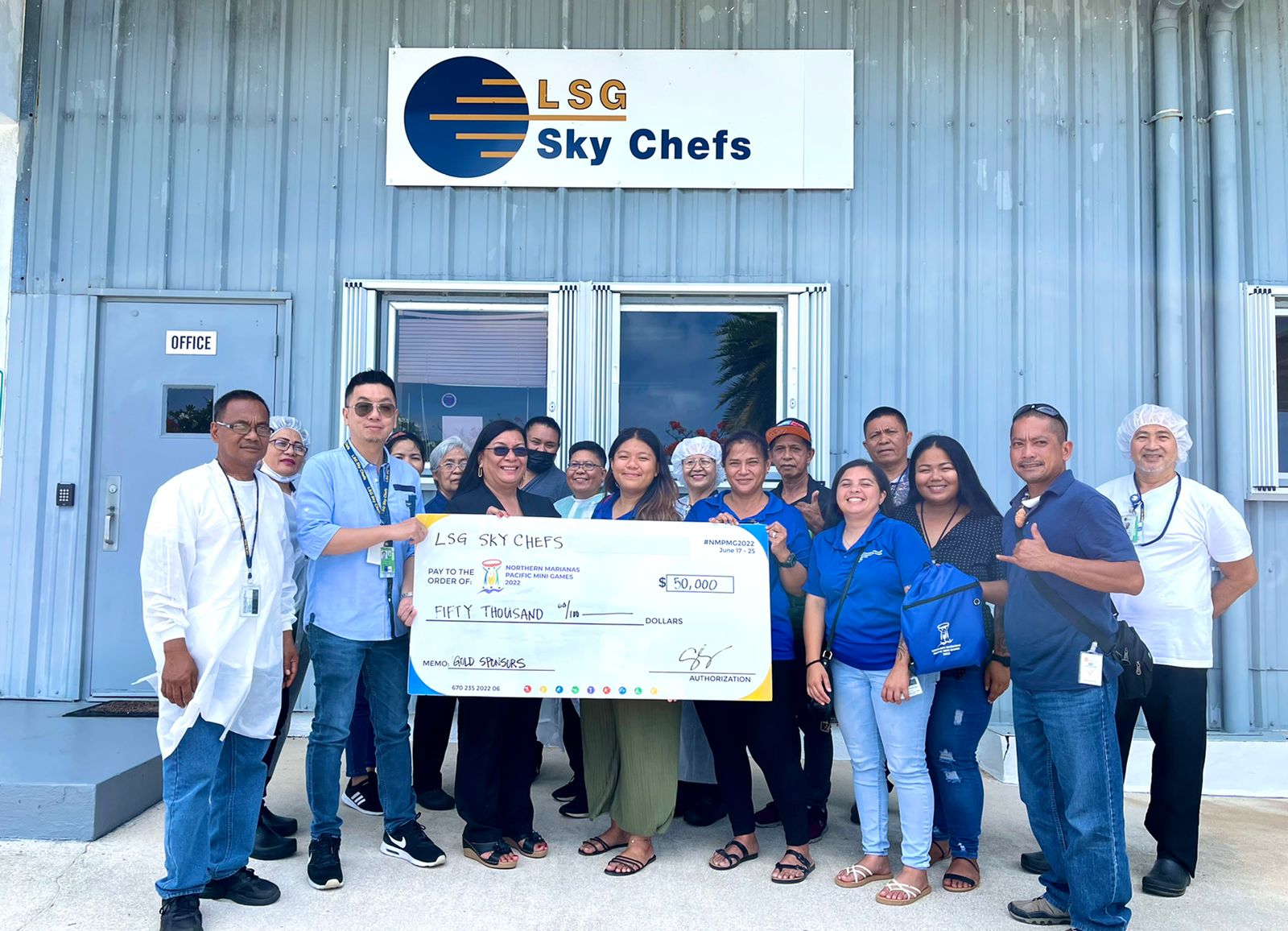 LSG Sky Chefs employees and Northern Marianas Pacific Mini Games Organizing Committee members pose for a photo with the $50,000 check donation Monday at the LSG office  in Dandan.