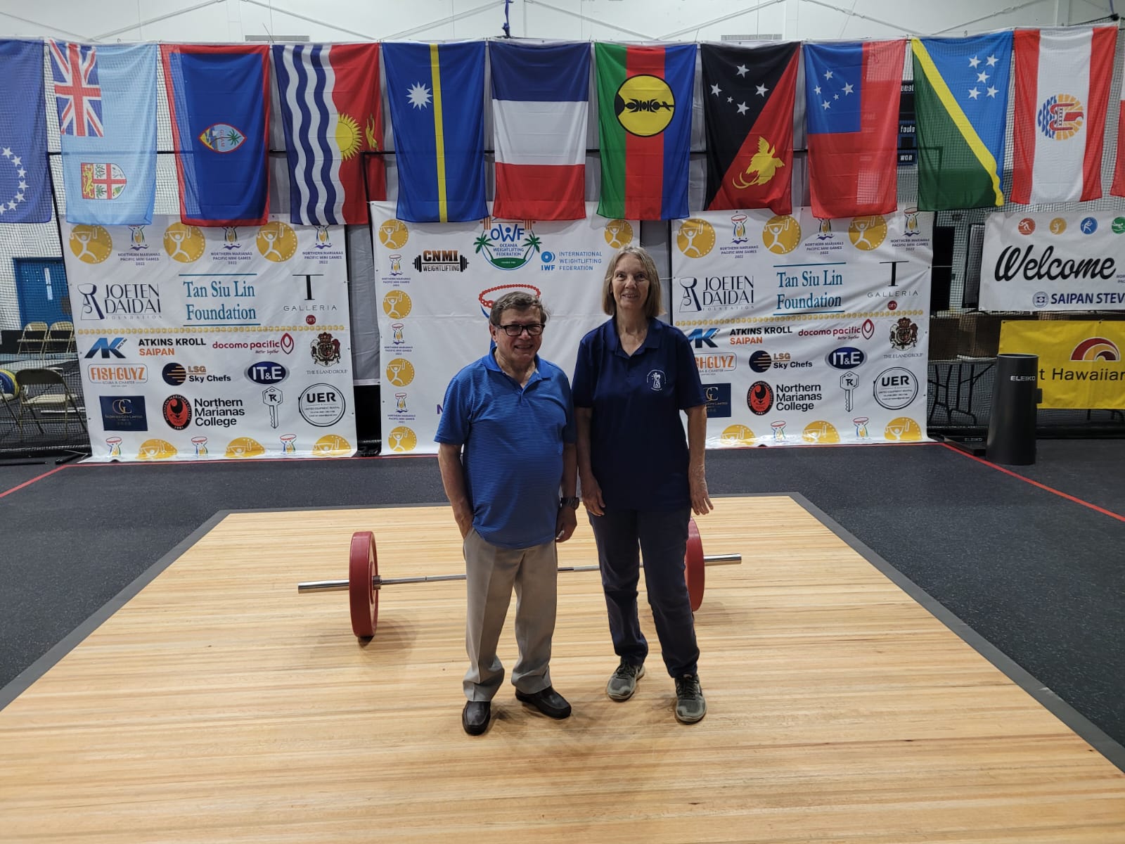 Oceania Weightlifting Federation General Secretary Paul Coffa and CNMI Weightlifting General Secretary Jeanne Rayphand pose for a photo in the weightlifting venue of the 2022 Pacific Mini Games at the MHS gym on Monday.