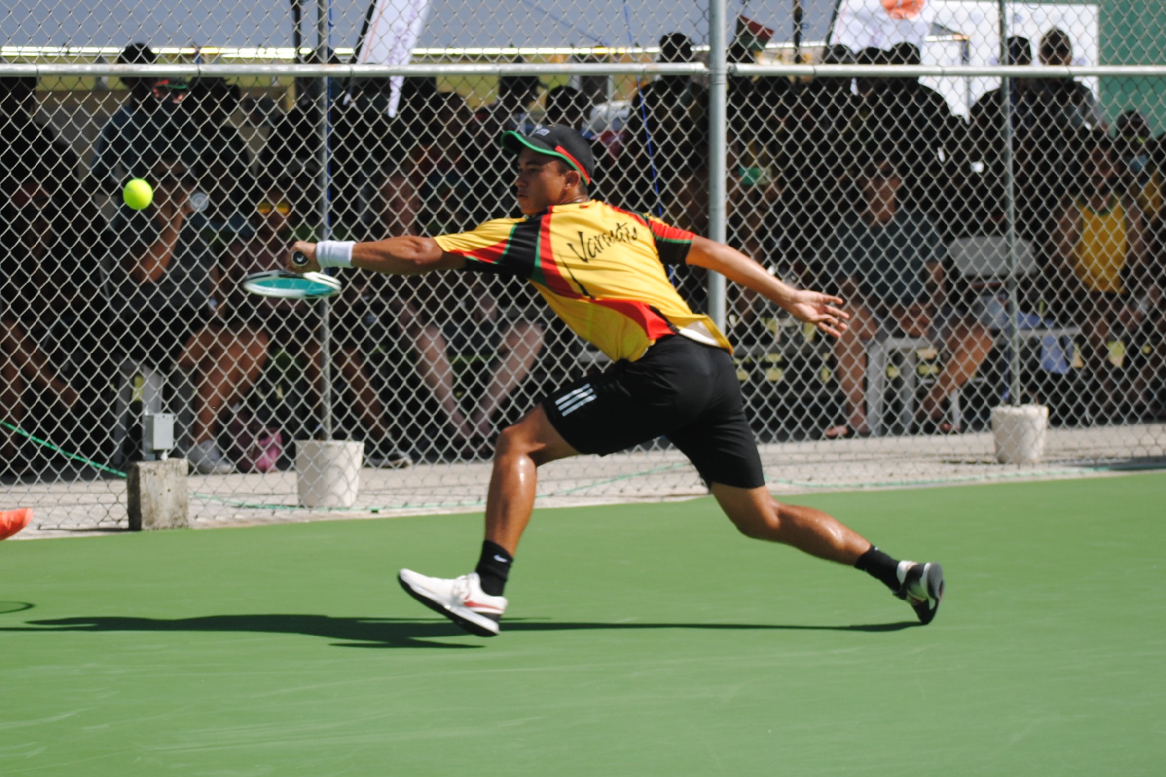 Vanuatu's Clement Mainguy extends for the return during the Men's Singles tennis finals of  the 2022 Pacific Mini Games at an American Memorial Park tennis court on Saturday.