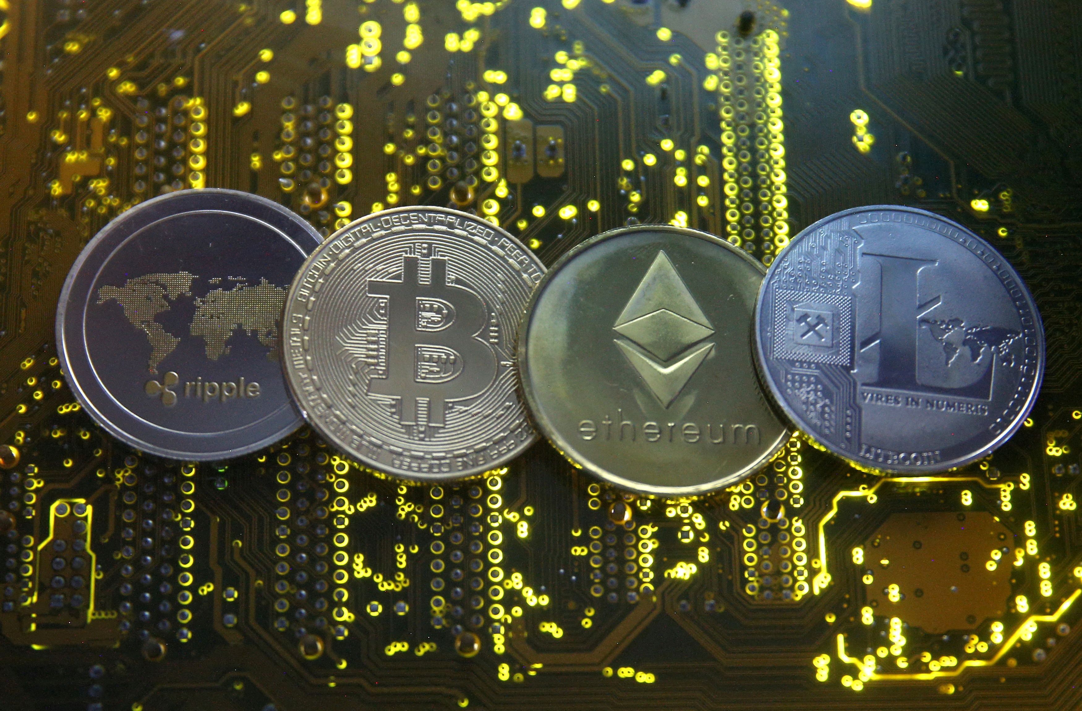 Representations of the Ripple, Bitcoin, Etherum and Litecoin virtual currencies are seen on a PC motherboard in this illustration picture on Feb. 14, 2018.