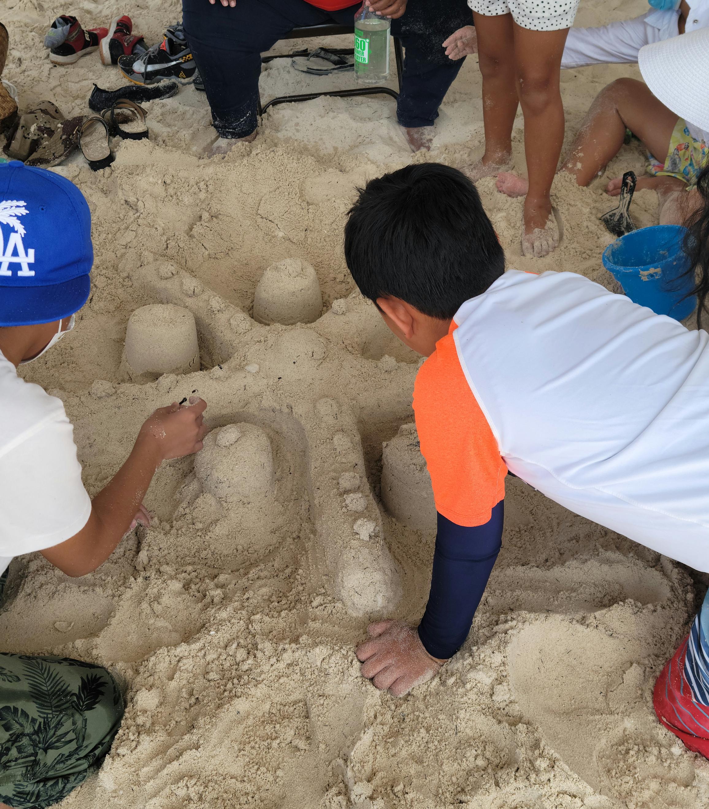 Young sand sculptors work on their "Bikini Bottom" entry.