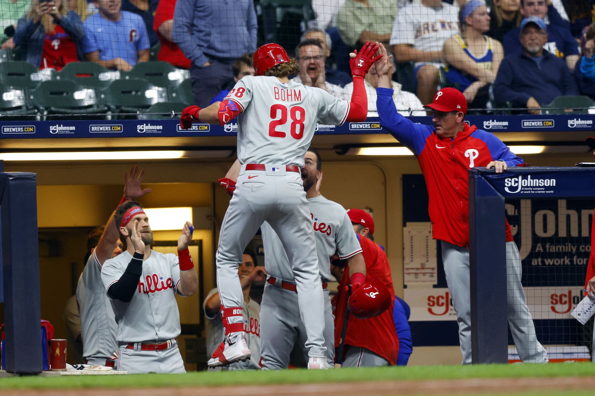 Philadelphia Phillies third baseman Alec Bohm (28) high fives teammates after hitting a home run during the ninth inning against the Milwaukee Brewers at American Family Field in Milwaukee, Wisconsin on June 7, 2022.