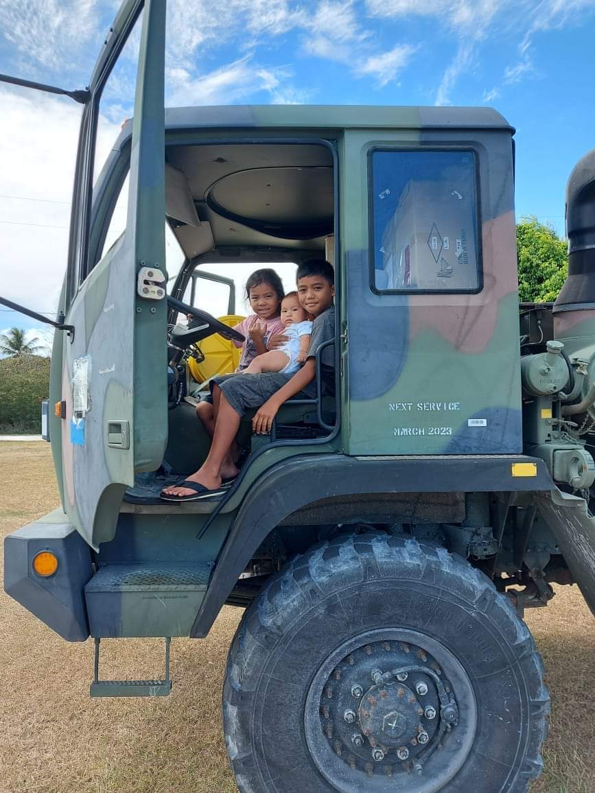 Children pose for a photo in an oversized semi-truck.