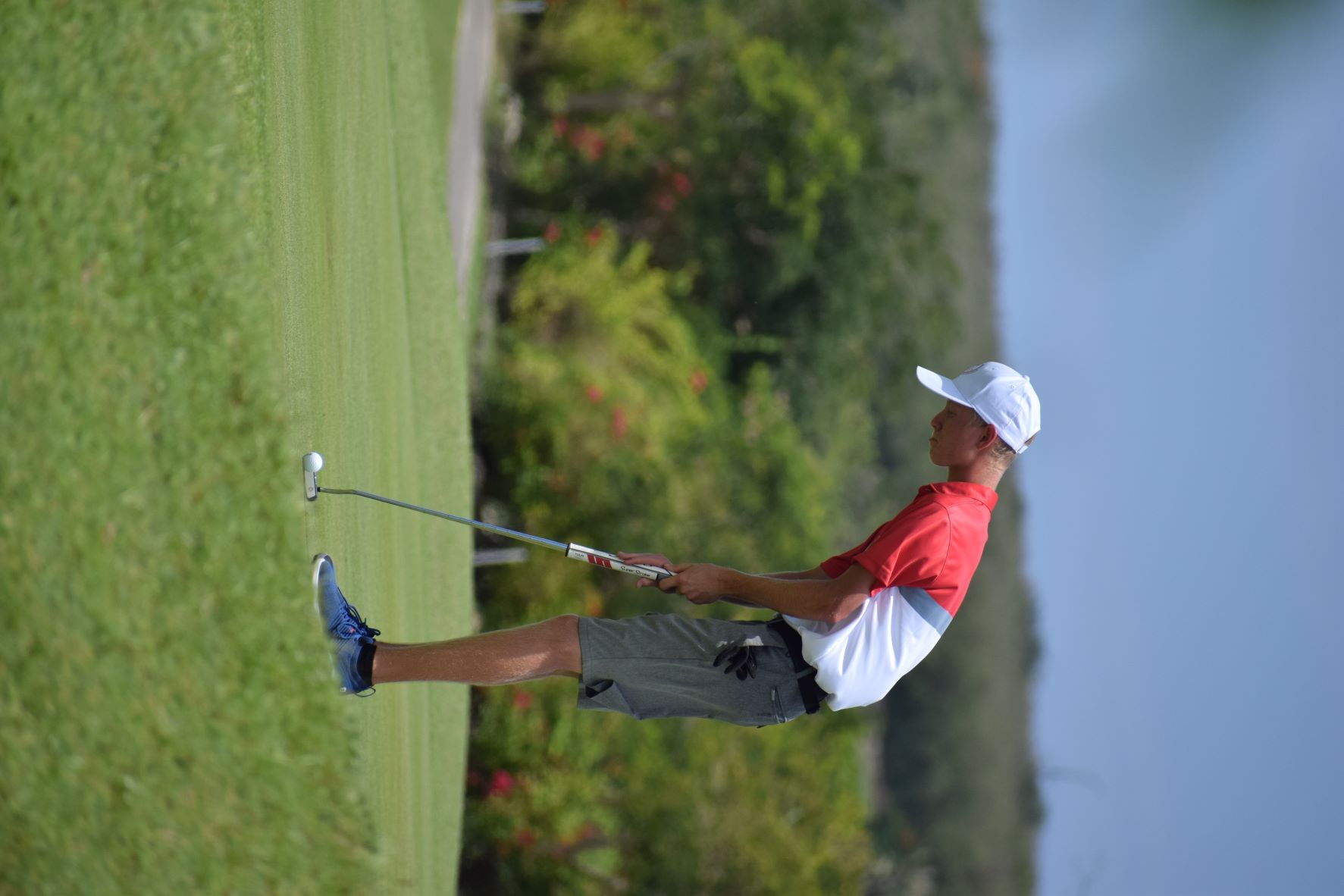 New Caledonia's Koch Hugo putts for a birdie during the men's golf event on Thursday.