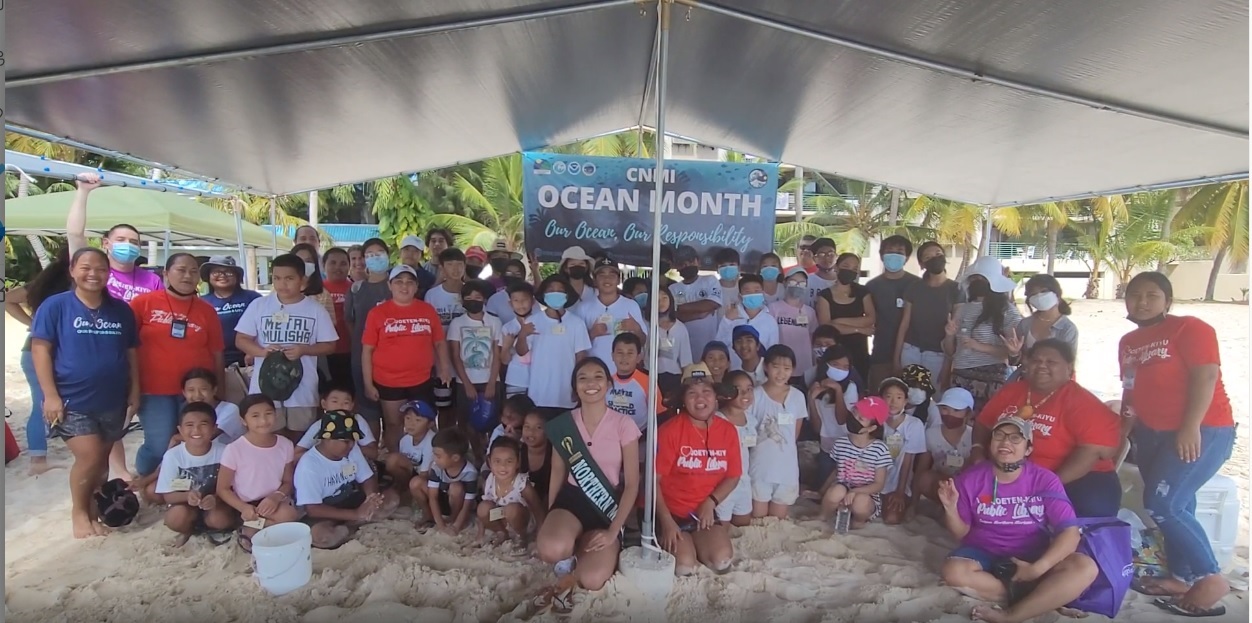 2021 Miss Earth NMI Crystal Fiona Rio poses for a photo with students, Joeten-Kiyu Public Library and Division of Coastal Resource Management staff in the beach area near Sandy Beach Homes in Chalan Kanoa.