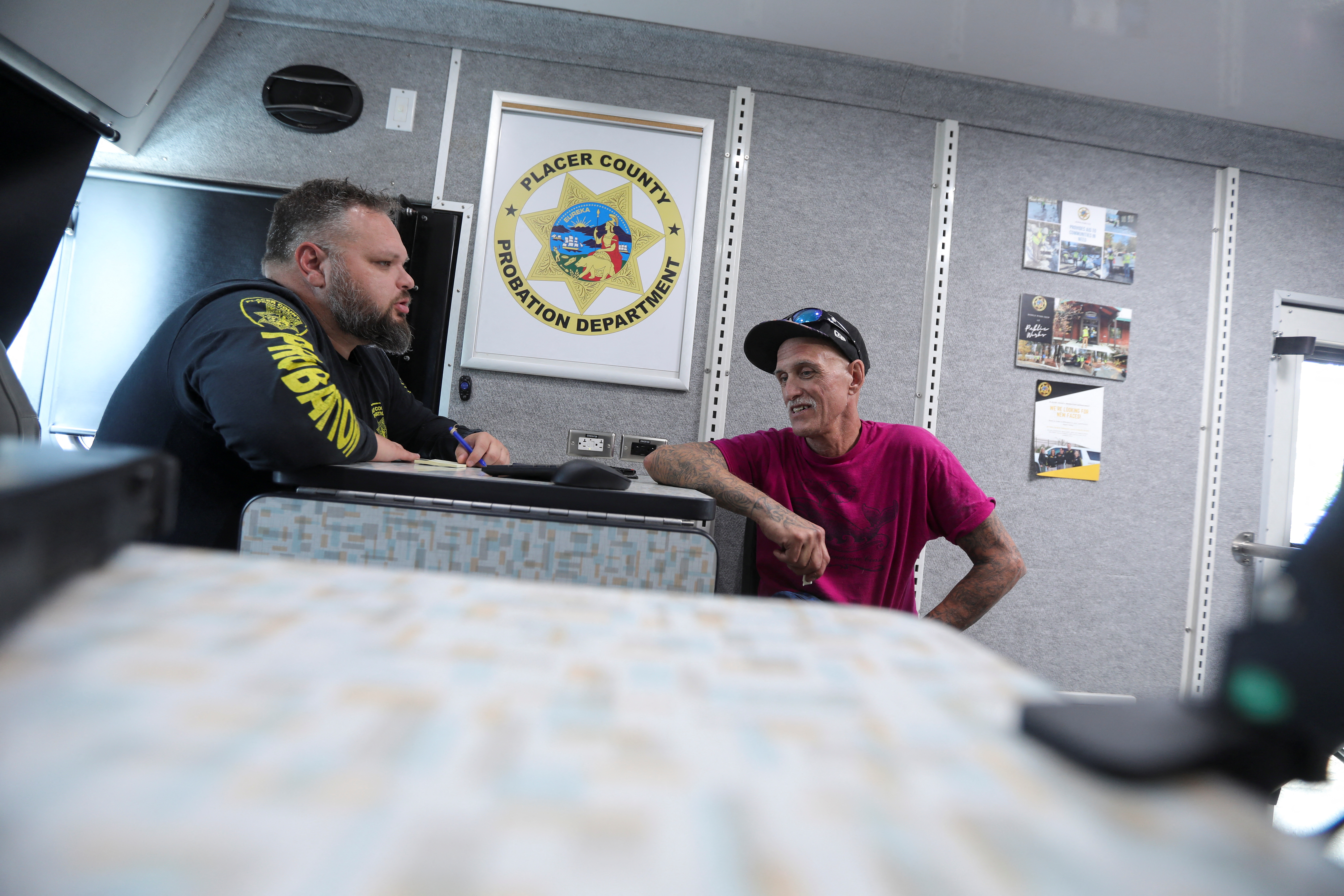 Kevin Fisk speaks with deputy probation officer TJ Fallon inside the Placer County Probation Outreach Vehicle in Auburn, California, on June 3, 2022.