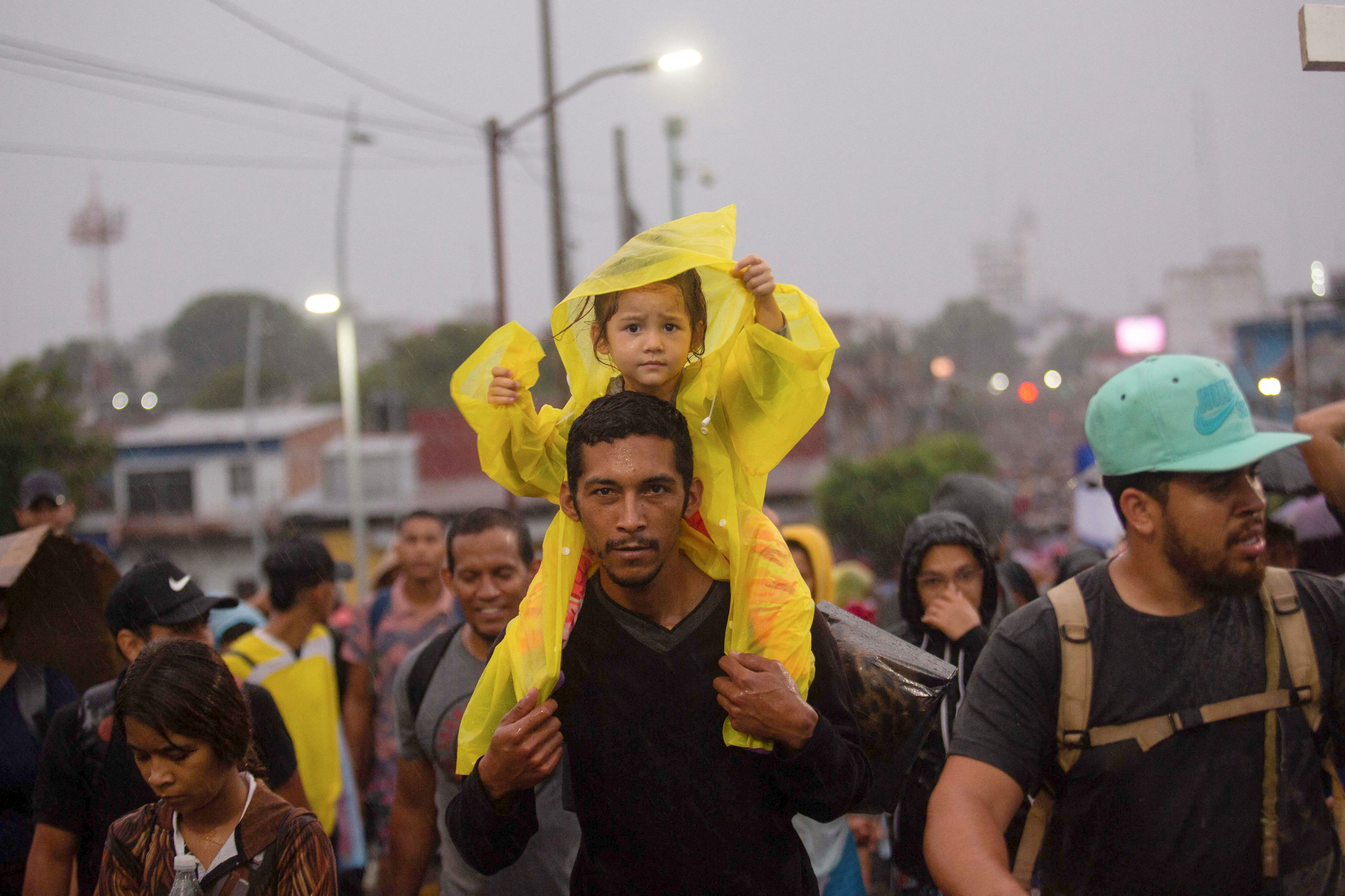 A child sits on a man's shoulders as migrants take part in a caravan in Tapachula, Mexico on June 6, 2022 as they attempt to cross the country and reach the U.S. border while regional leaders gather in Los Angeles to discuss migration and other issues.