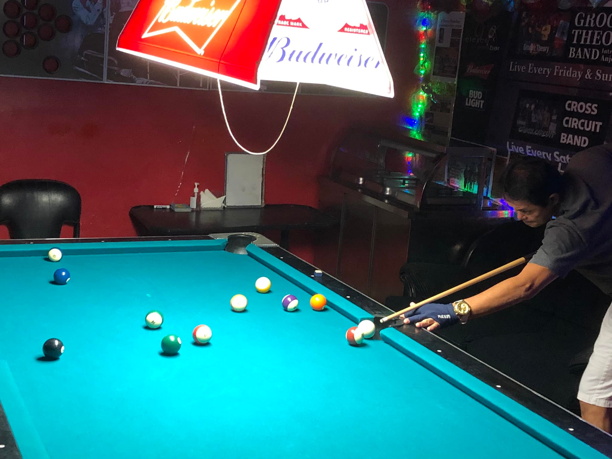 9 Eleven Rebels 2's Rey Hermogenes lines up for a shot from the side pocket during a Thursday Division game of the SBA Budweiser Open 8-Ball League at 9 Eleven Restobar.