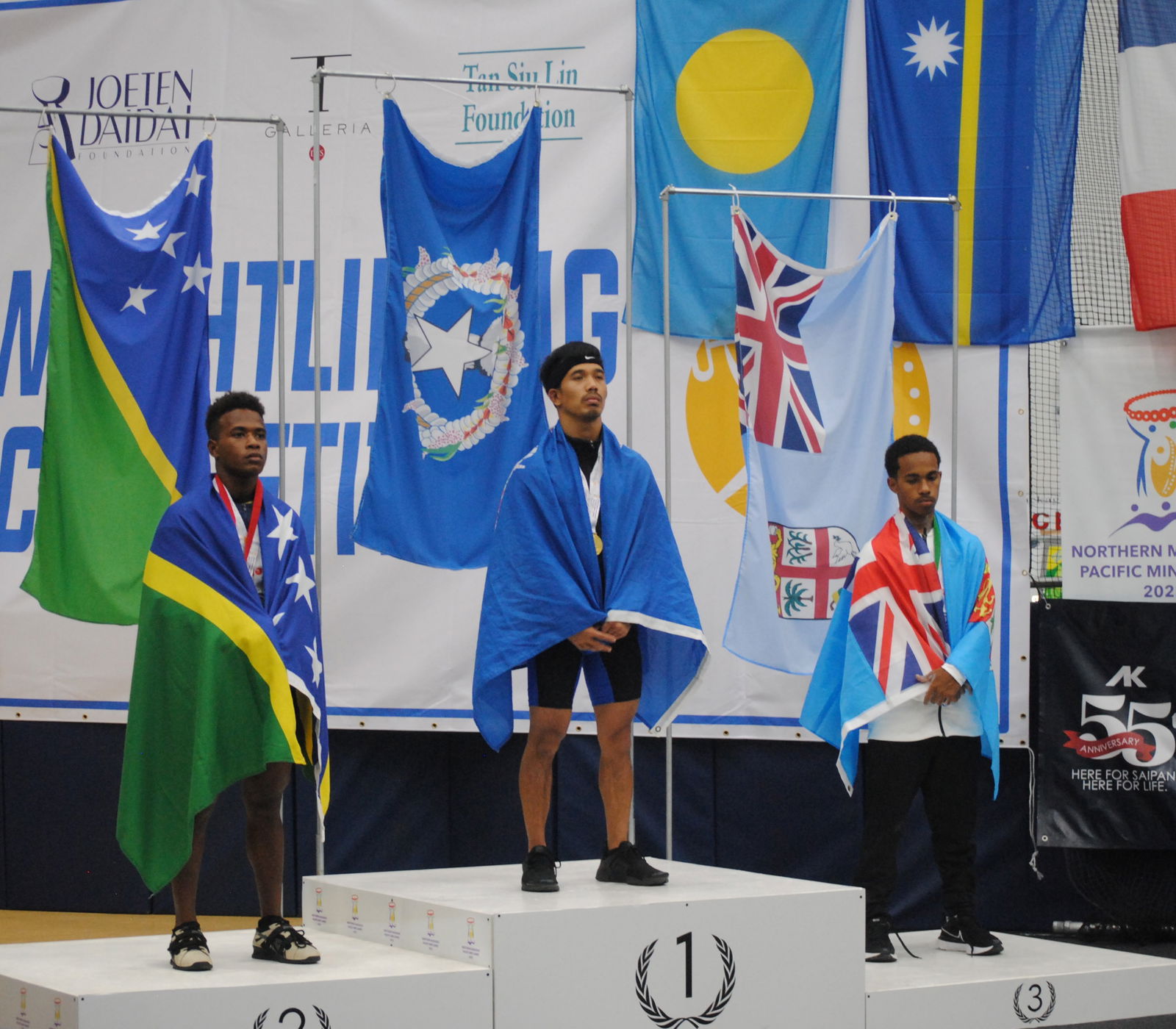Gold medalist Ray Santos of the NMI, center, with the Solomon Islands' Phllip Masi, left, who earned the silver medal, and Fiji's Eroni Vuratu, who received the bronze, during the weightlifting medal ceremony of the 2022 Pacific Mini Games Monday at the MHS gym.
