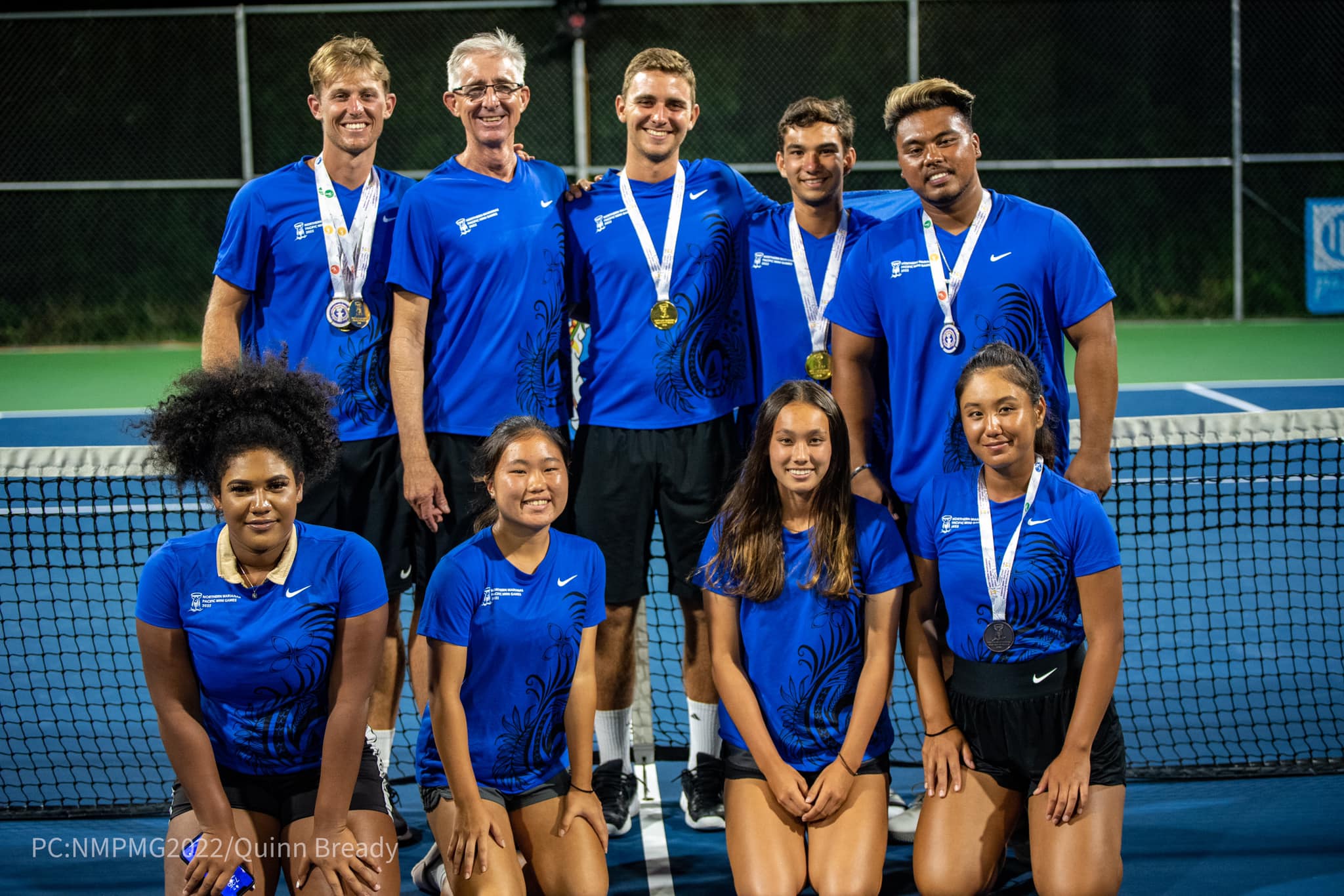 NMI tennis team coach Jeff Race, second  left, standing, with Colin Sinclair, left standing, and the other members of the local team pose for a photo at the American Memorial Park tennis courts.