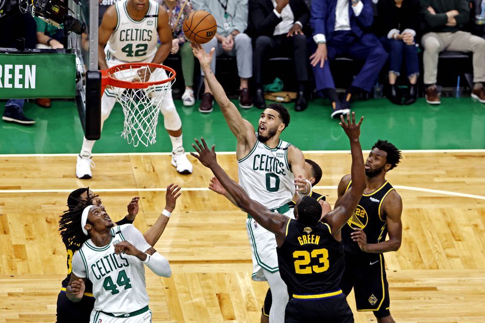 Boston Celtics forward Jayson Tatum (0) shoots the ball against Golden State Warriors forward Draymond Green (23) during the fourth quarter in game three of the 2022 NBA Finals at TD Garden in Boston, Massachusetts on June 8, 2022.